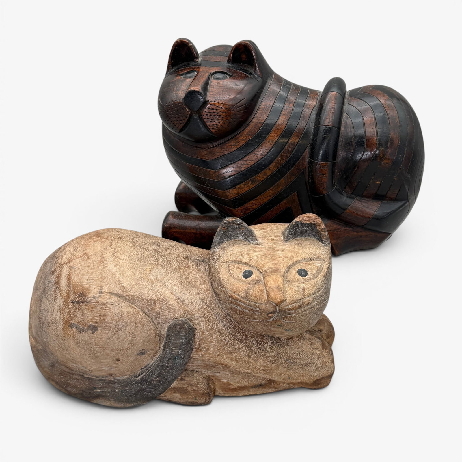 Pair of Carved Folk Art Wood Cats: Each 20th century, bulbous in form, possibly doorstops, one with old painted surface and the other carved in mixed woods, with compartment underneath. Longest lg. 10"
