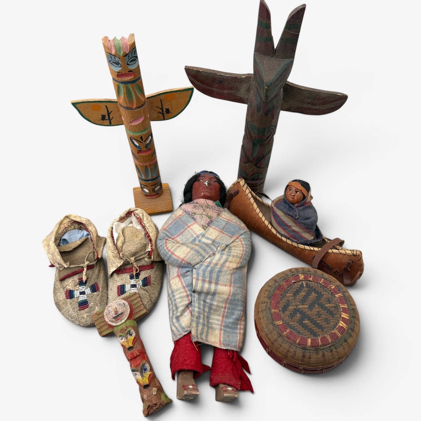 Katsina, Canoe, Moccasins, Totems, and Basket: All trade wares, including child moccasins, a katsina, 3 totems, and a basket. Tallest ht.