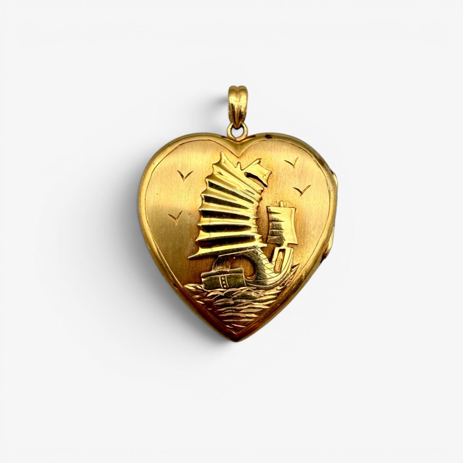 22K Gold Heart Locket: Decorated with lighthouse to front and sailboat to reverse. Marked 22k inside locket. Total weight: .23 troy ounces