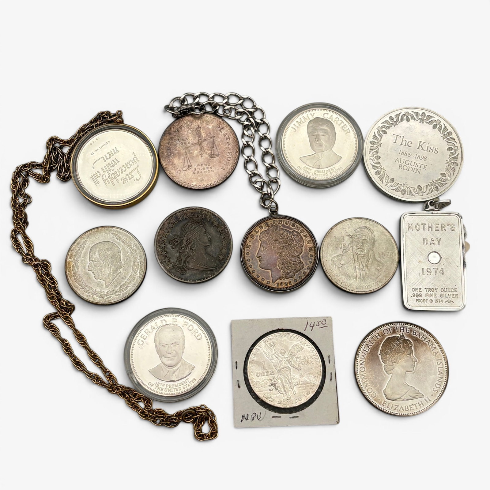 Group of Silver Coinage, Varying Countries: Including a commemorative Auguste Rodin coin, a one ounce liberty, two presidential coins, one Elizabeth II, one 1921 liberty with bezel and chain, one mother's day 1 troy oz. necklace and additional 
