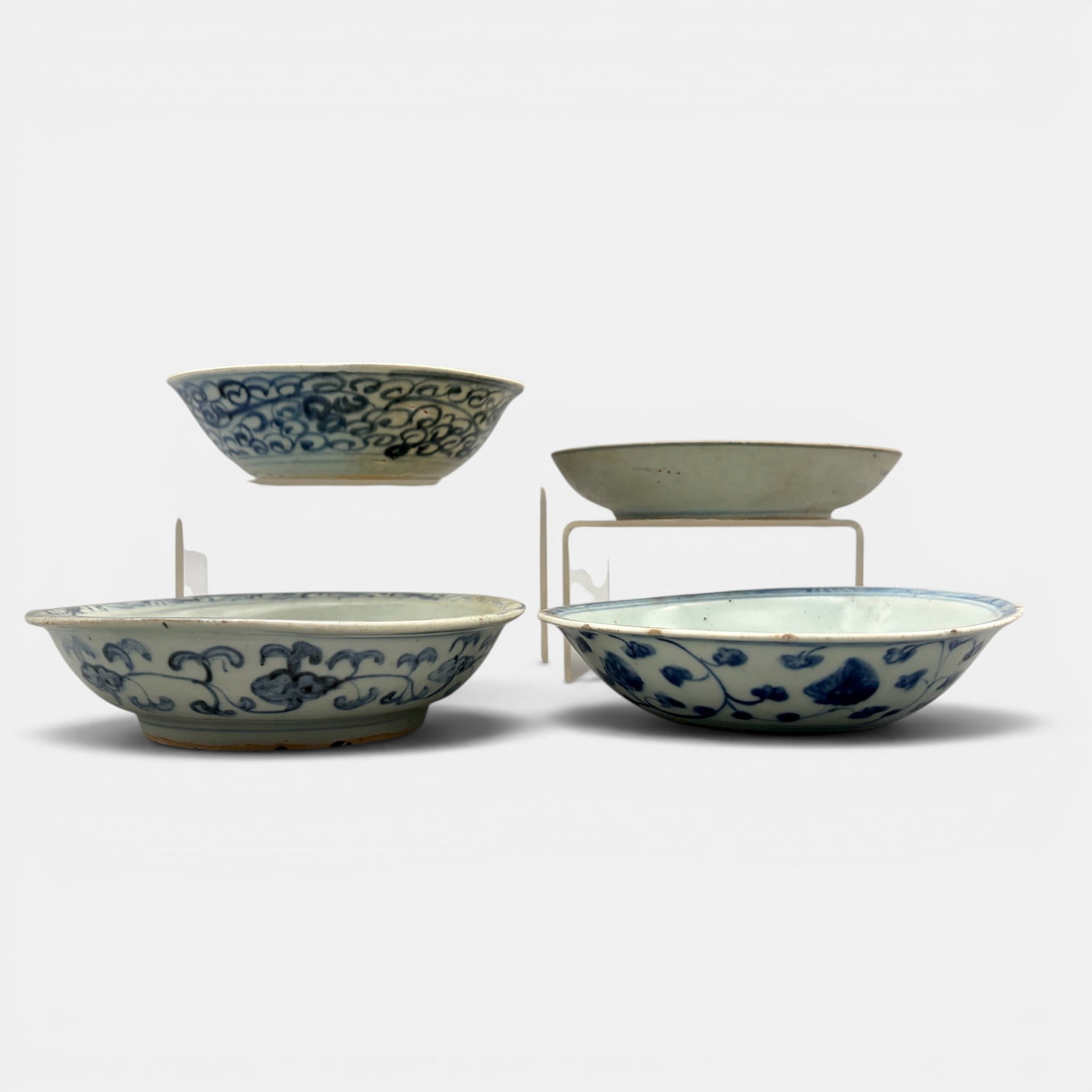 Four Ming Blue and White Dishes: All Ming, all decorated in underglaze blue. One with horse and rider, other with florals, others with faint decoration. Largest diameter: 5.5"