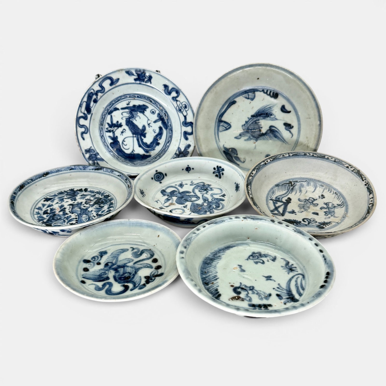Seven Ming Blue and White Dishes: All Ming, all decorated in underglaze blue. All with varying forms of decoration. Largest diameter: 6"