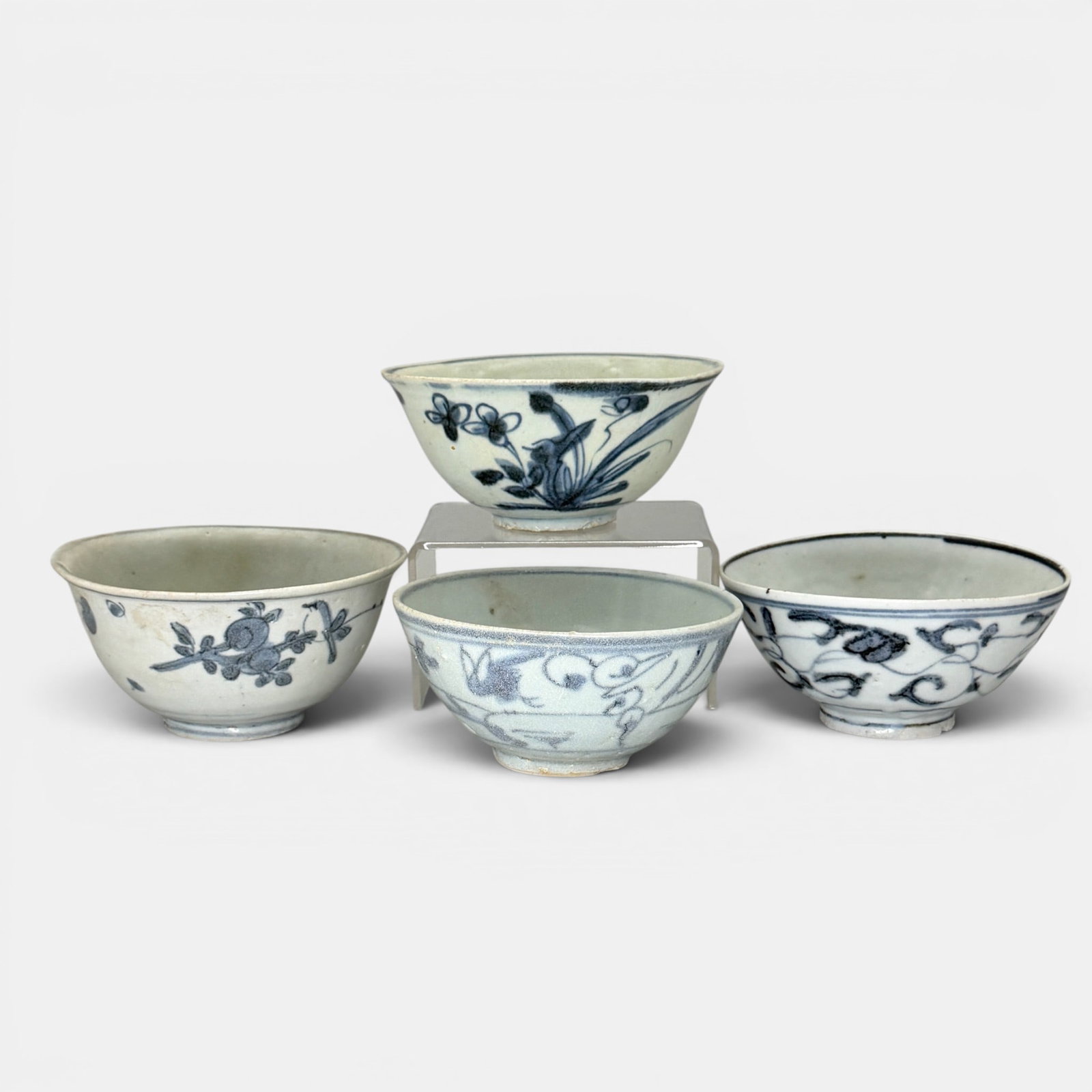 Four Ming Blue and White Bowls: Four smaller blue and white bowls, one with deer, the other with plant or flower designs. Largest ht. 2.5", diameter 4.75".