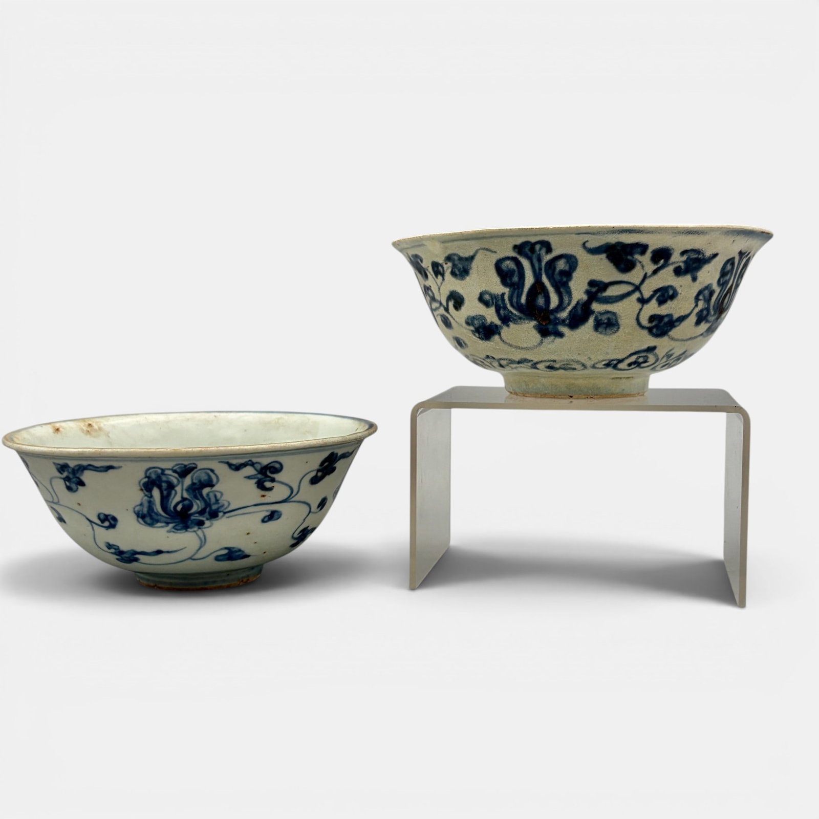 Pair of Ming Blue and White Bowls: Each early Ming, with flowing plant and floral designs in underglaze blue. Each 2.5" ht., diameter 6".