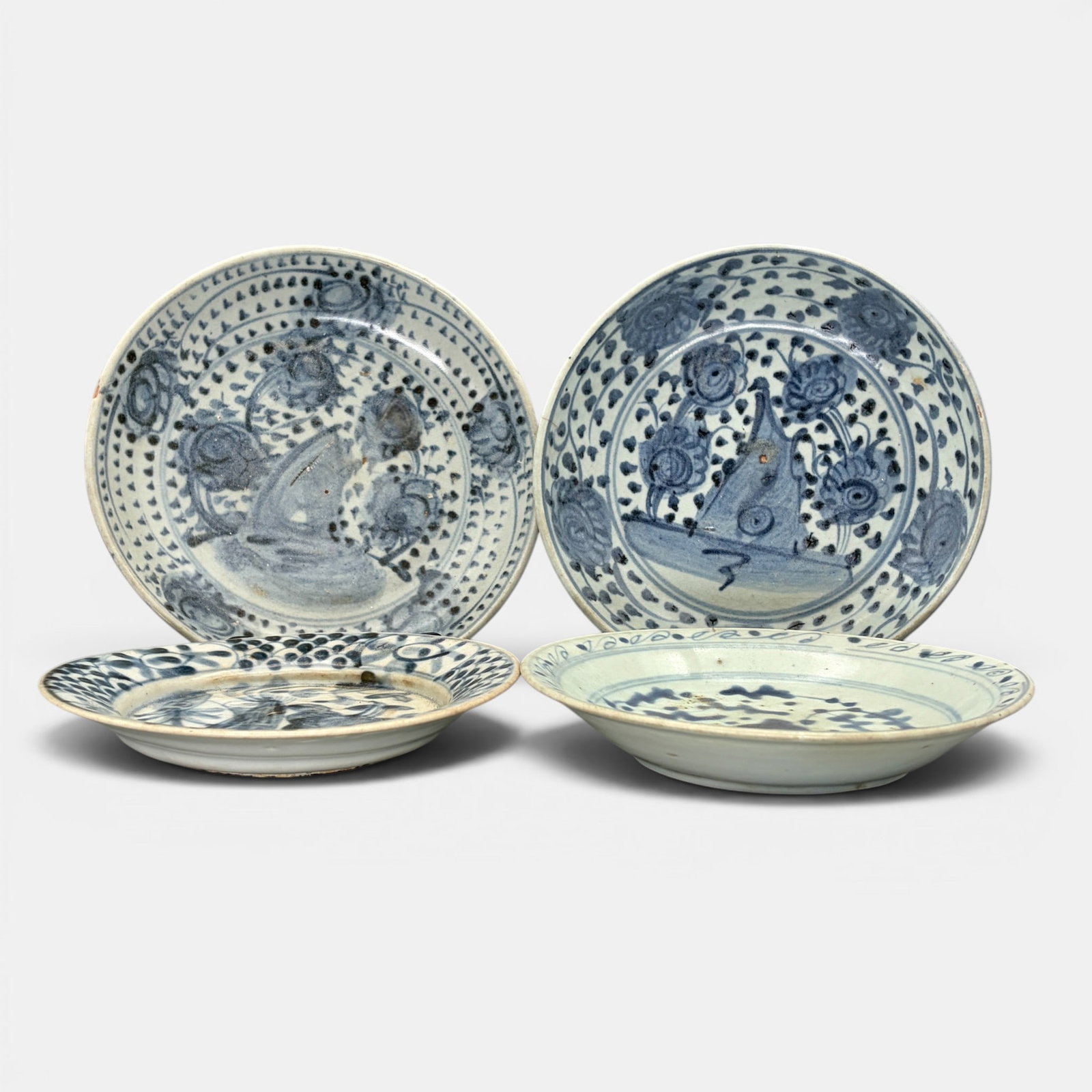 Four Ming Blue and White Dishes: All decorated in underglaze blue with florals and repeating scrolling patterns. Largest diameter: 7.5"