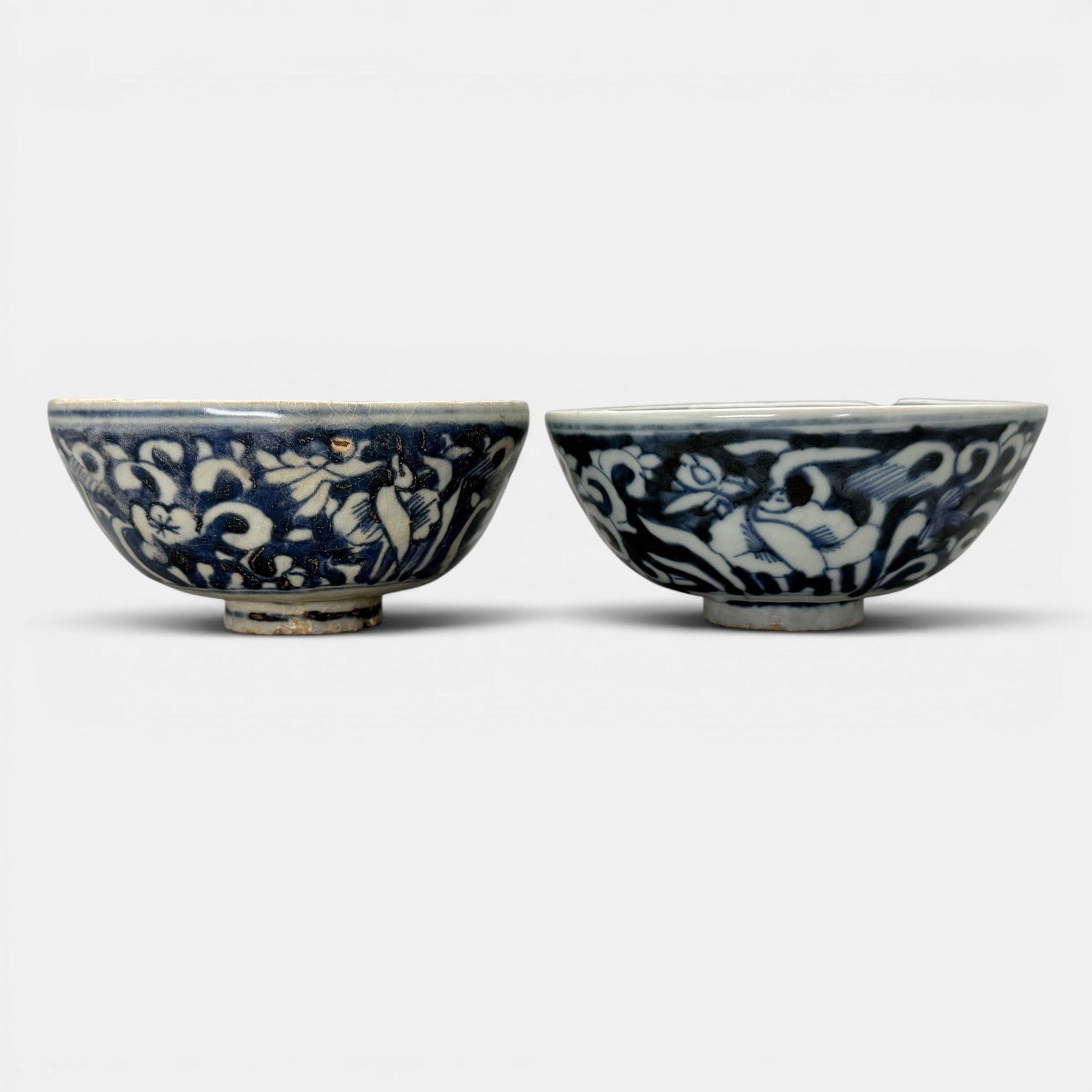 Pair of Ming Blue and White Bowls: With reverse blue underglaze, revealing in standing birds among plants in the white porcelain glaze. Ht. of each 2.75", diameter 6".