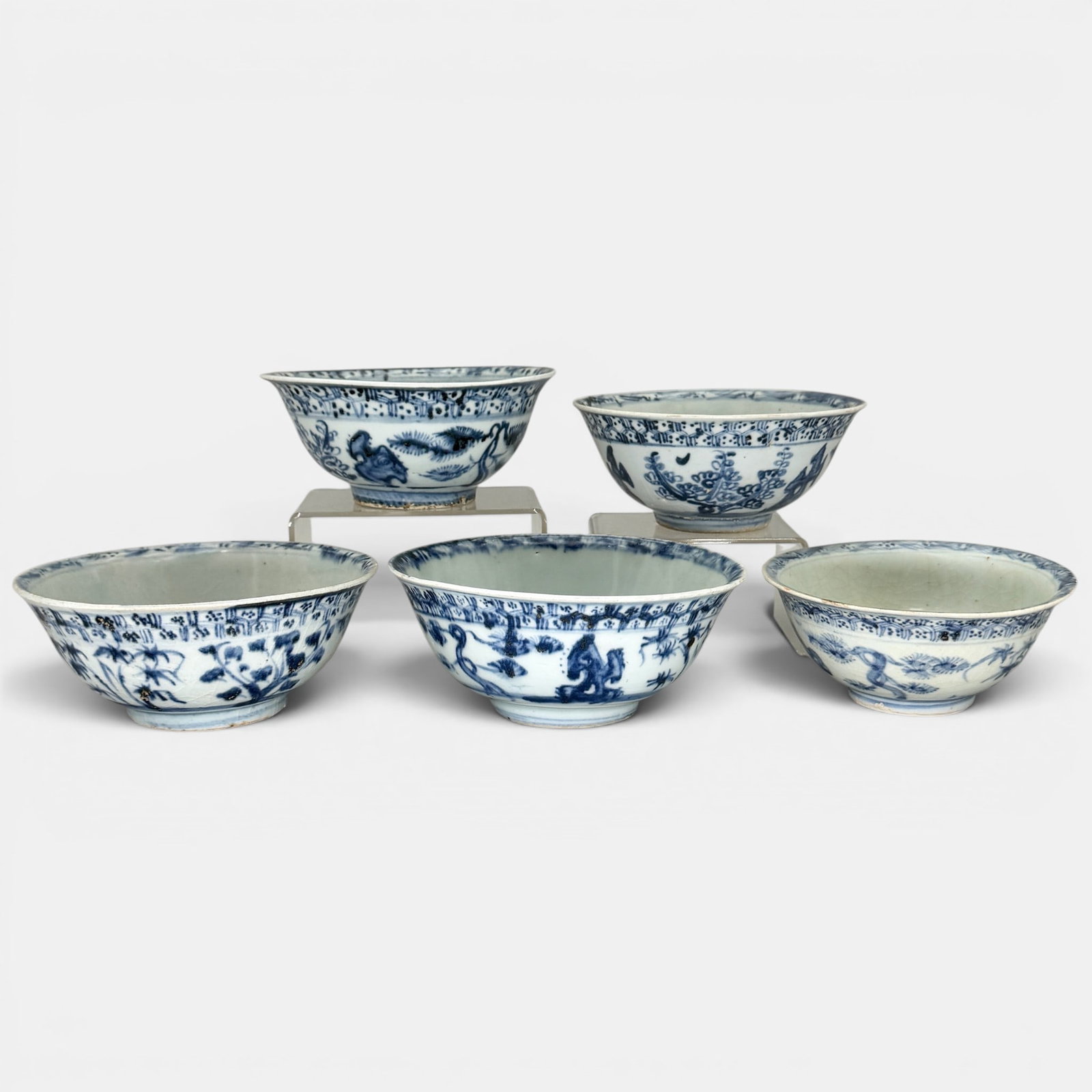 Five Ming Blue and White Bowls: Including five Ming period bowls, each with a similar honeycomb pattern near the rim, and foliage landscapes to the body. Largest ht. 2.5", diameter 6".