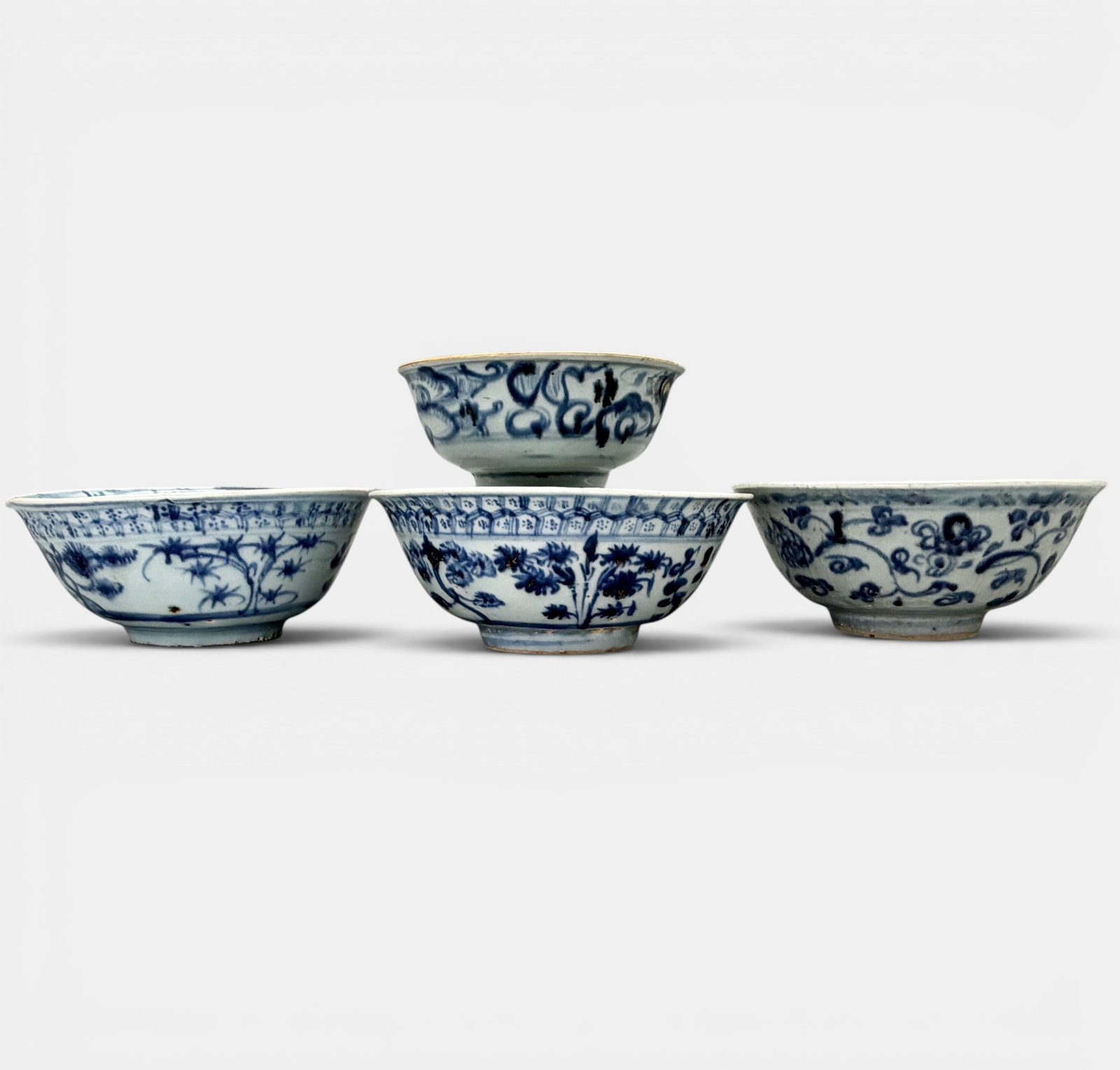 Four Ming Blue and White Decorated Bowls: All Ming, all decorated in underglaze blue to exterior and interior. One with mottled interior decoration and one crazed to interior and exterior. Largest diameter: 6"
