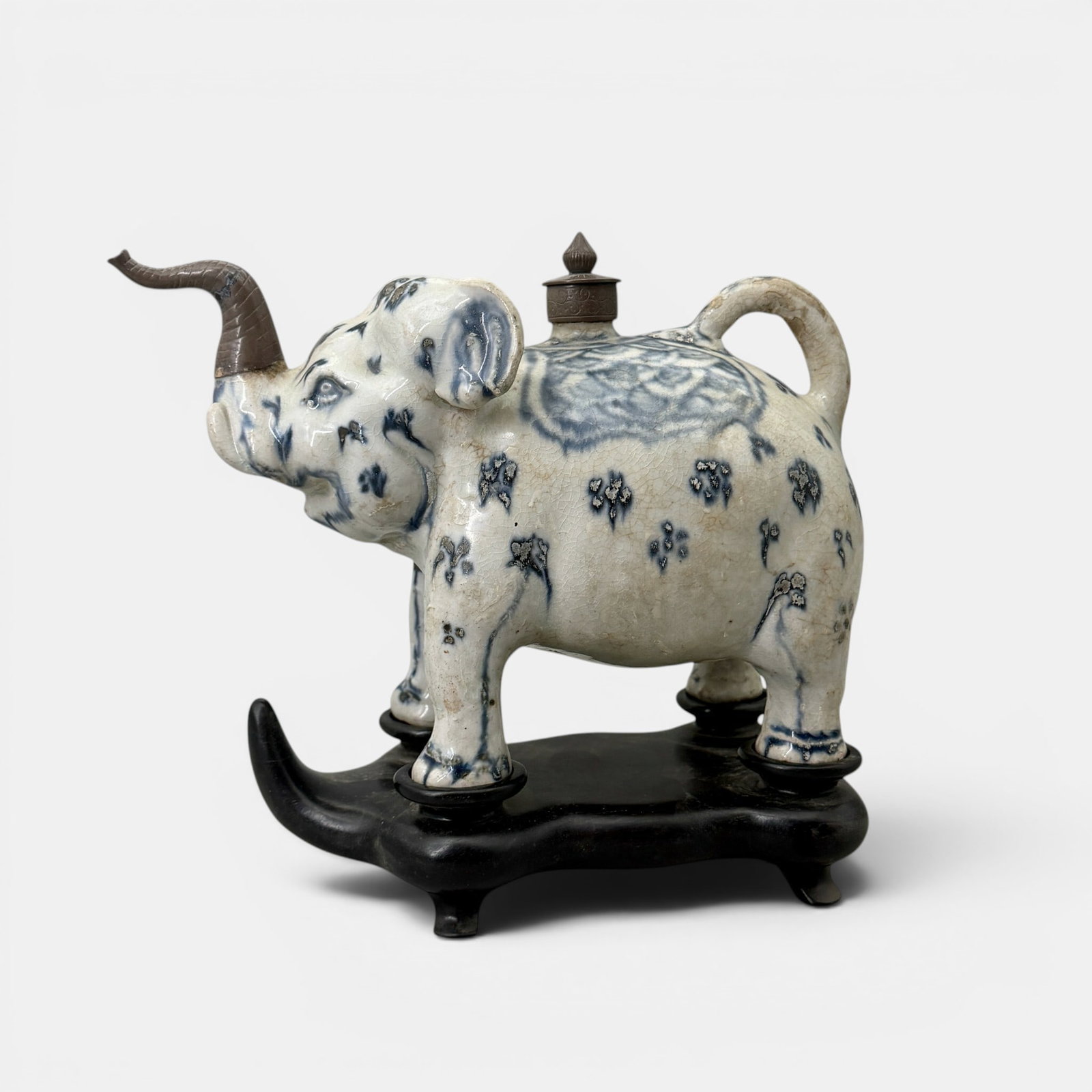 Annamese Blue and White Porcelain Elephant: Circa 15th century, Annamese elephant with underglaze blue and white decoration. In later box and stand for the elephant. Spout and lid constructed of a mixed metal. Tail and spout still fully intact.