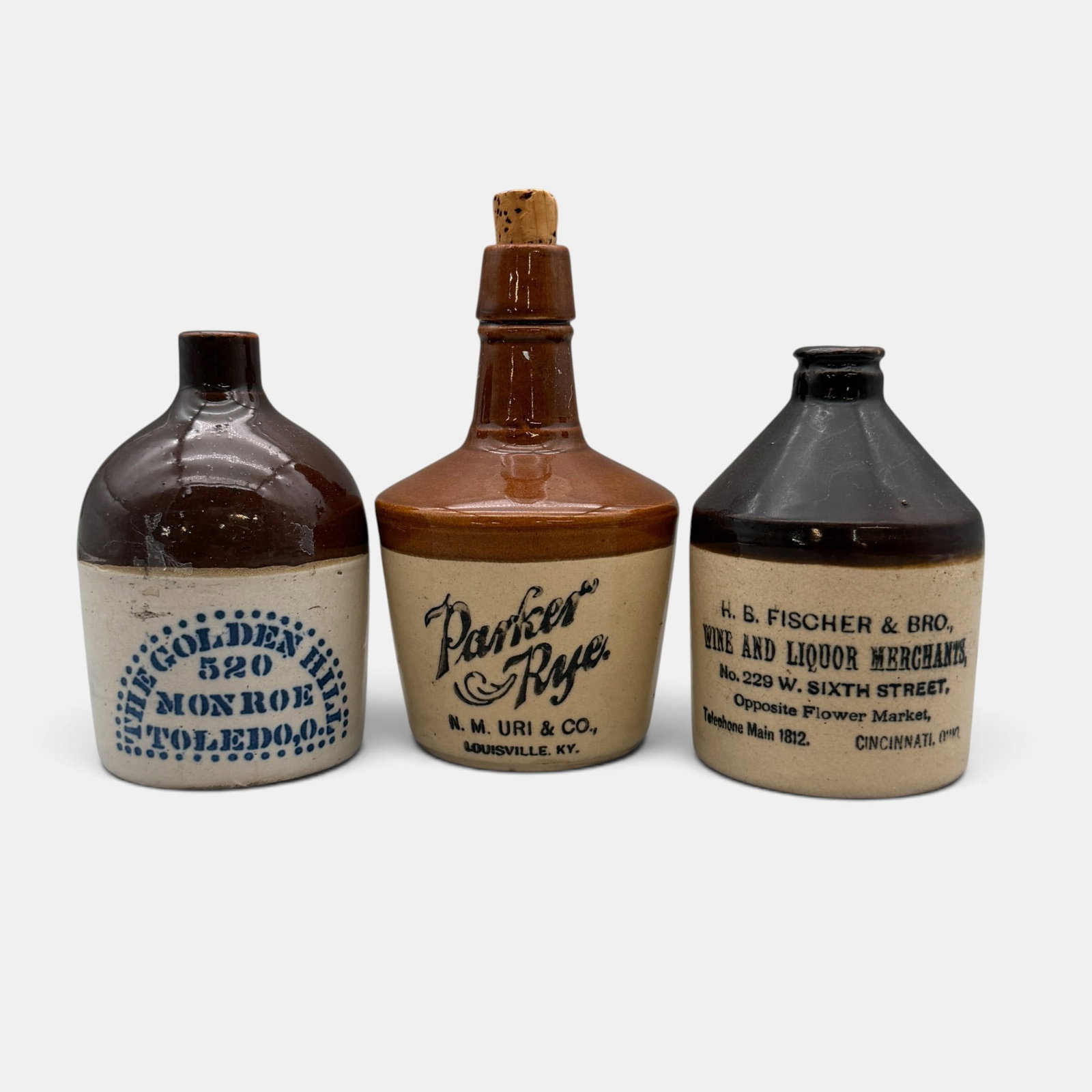 Group of 3 Small Whiskey Jugs, H.B. Fischer & Bro. Cincinnati, Plus: Three small two toned whisket jugs. 1. H.B. Fischer & Bro. Wine and Liquor Merchants No. 229 W. Sixth Street Opposite Flower Market Cincinnati, Ohio. Height 4 1/2 inches. 2. Parker Rye jug made by N.N
