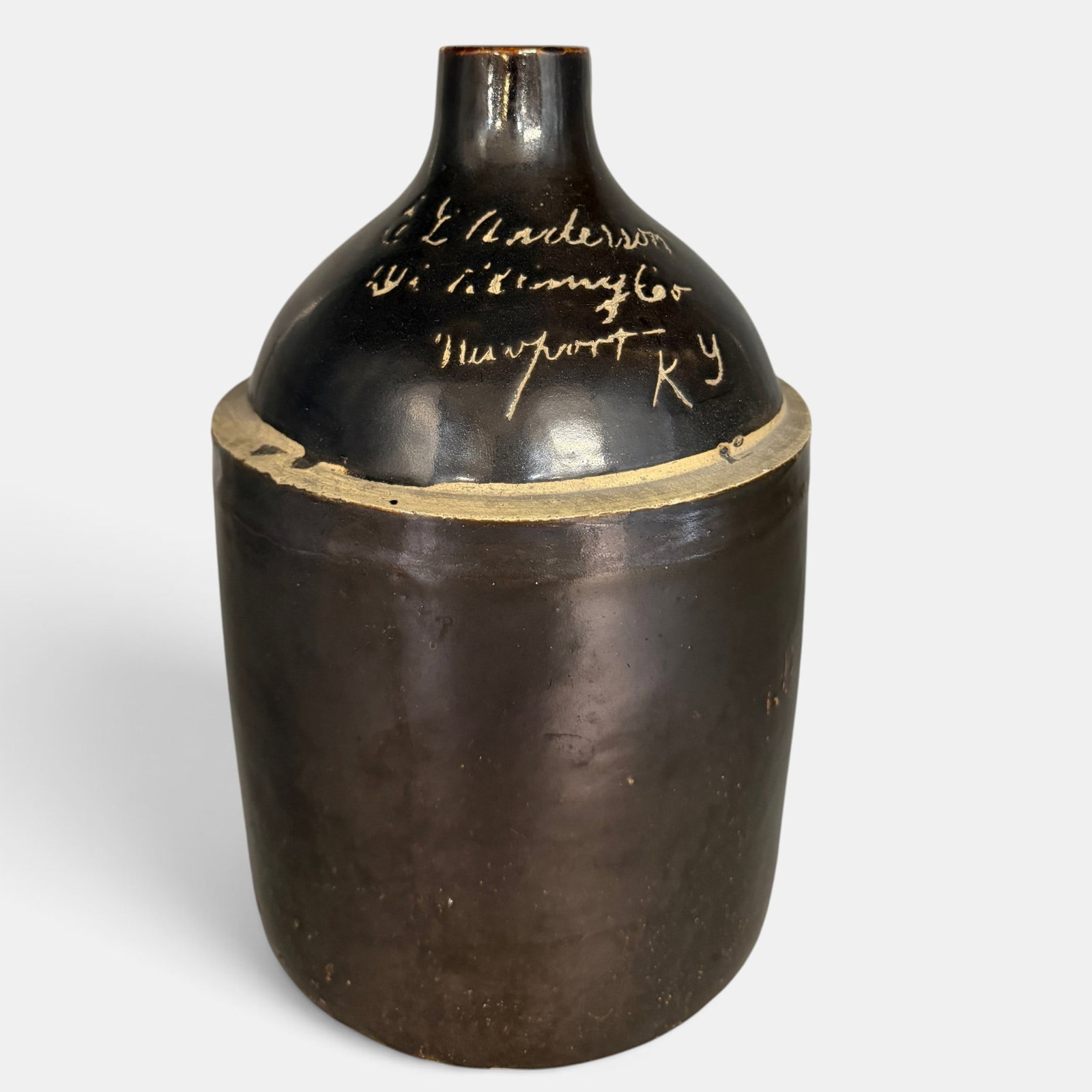 Brown glazed whiskey jug, C.L. Anderson Newport, KY.: Brown glazed whiskey jug, probably 1 gallon, incised on shoulder "C.L. Anderson (indecipherable) Newport, Ky. Height 10 3/4 inches. From the Jerry Stehlin Collection.