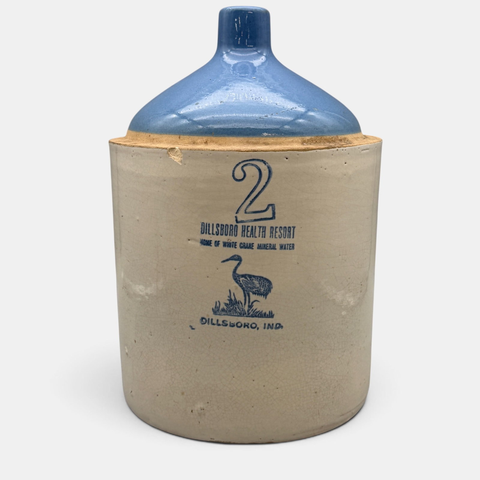 Rare Dillsboro Health Resort Decorated Stoneware Jug: Early 20th century with straight sided crock, sky blue glazed top with white glazed sides and cobalt stenciled number 2 and "Dillsboro Health Resort Home of White Crane Mineral Water." Picture of