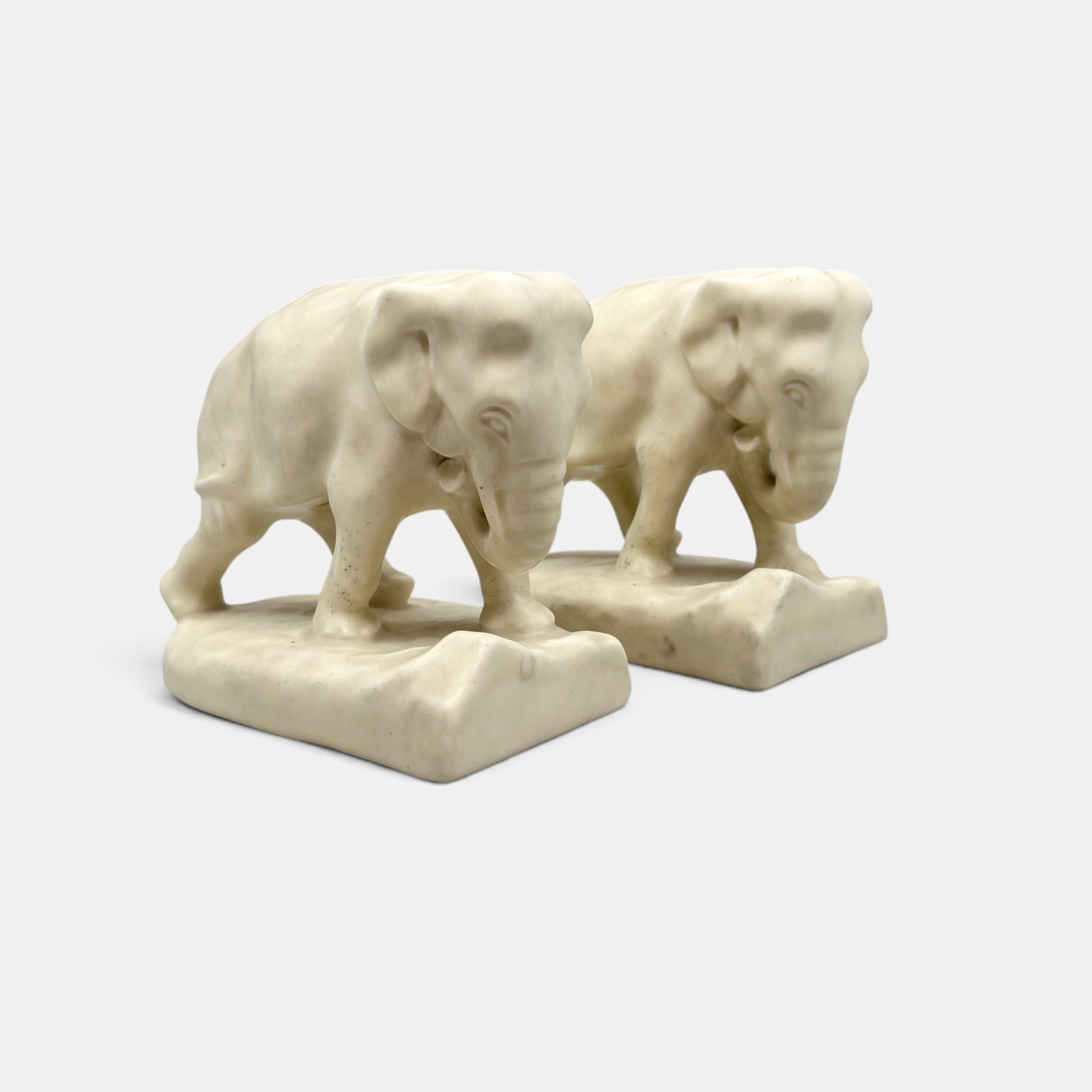 Pair of Rookwood Elephant bookends, 1928: Two Rookwood Elephant bookends in white mat glaze. Impressed Rookwood logo, XXVIII, Shape number 2444 D. Height 5 inches.