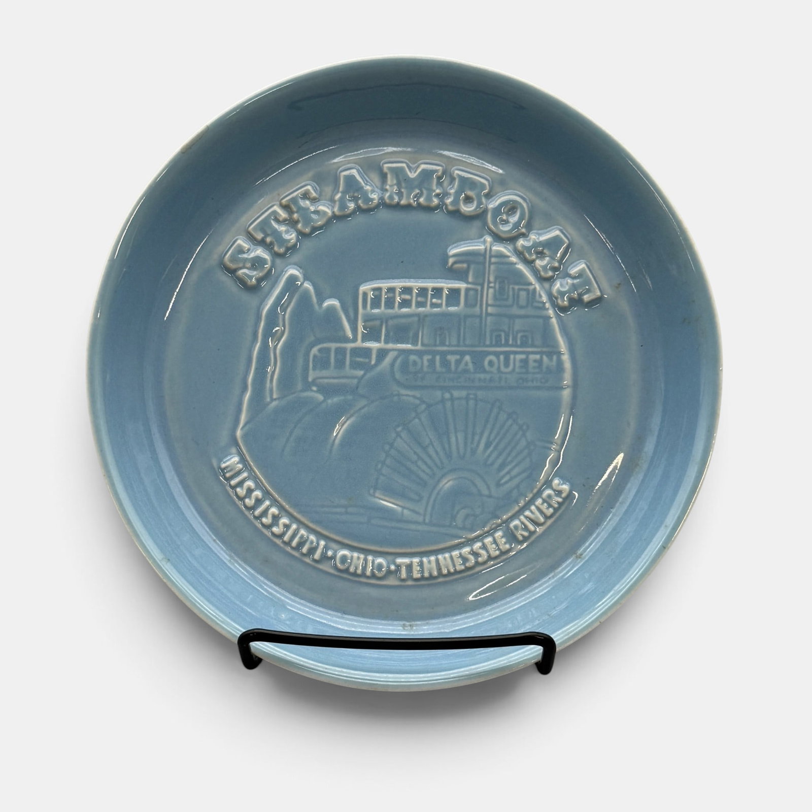 Rookwood "Delta Queen" tray in blue, 1964: Rookwood "Delta Queen" ashtray in blue, done in Starkvile in 1964 with the image of the famous paddle wheeler on the front. Impressed Rookwood logo, LXIV, Shape number 7232, Rookwood Pottery