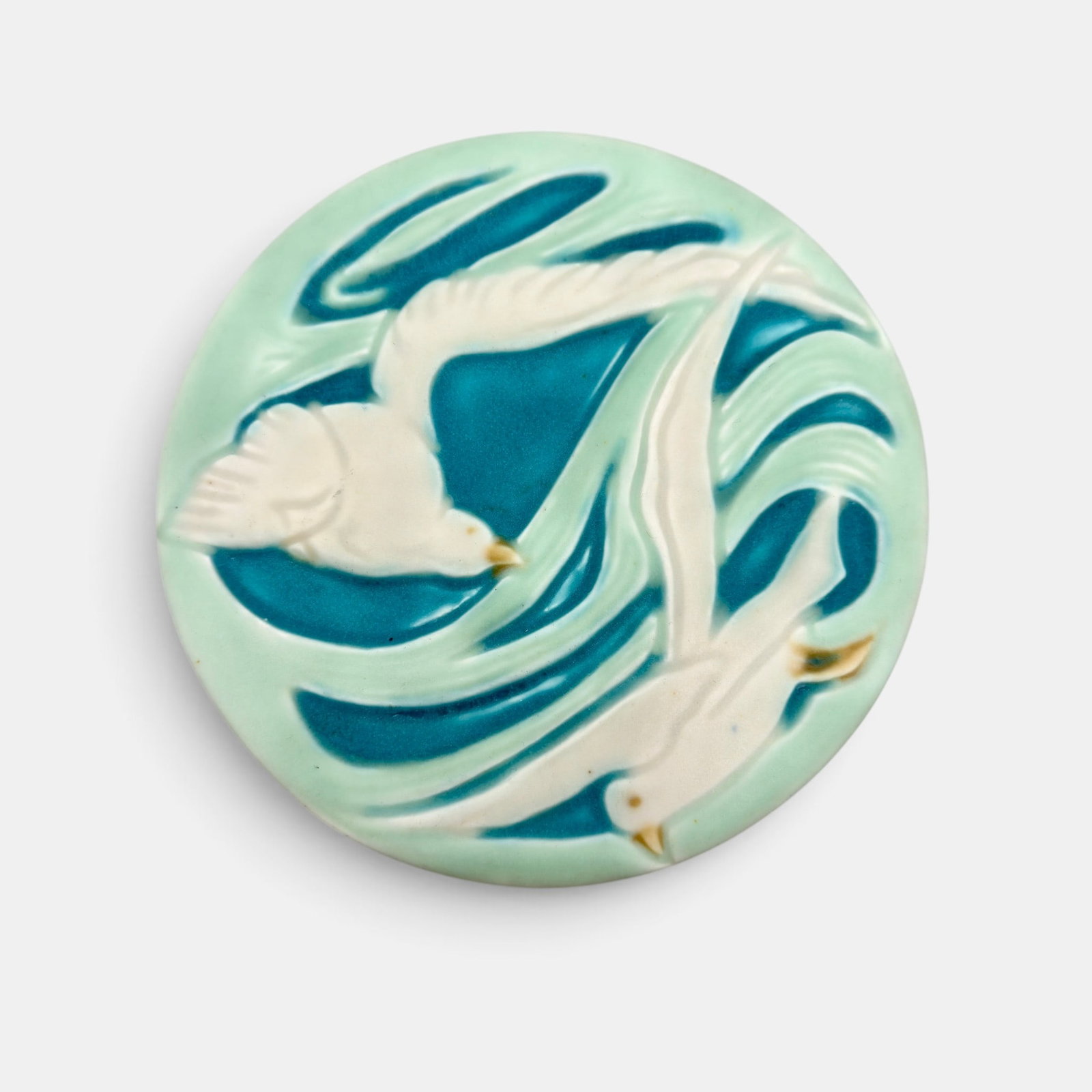 Rookwood trivet, sea gulls, 1925: Round Rookwood trivet with a pair of sea gulls in flight. Impressed Rookwoo logo, XXV, Shape number 2350. Height 1/2 inch, diameter 6 inches.