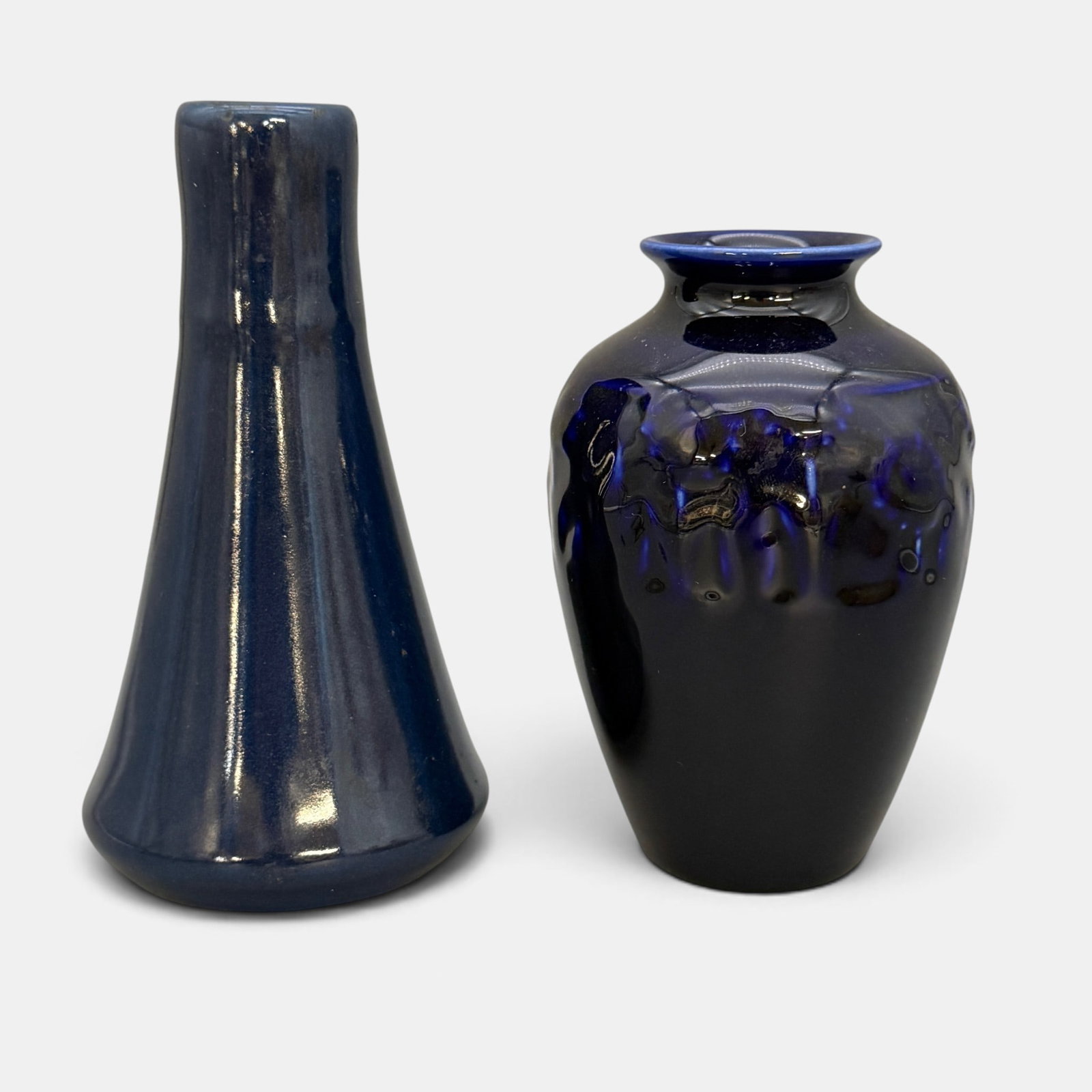 Two Rookwood production vases in purple, 1916 and 1936: Two Rookwood production vases in purple. Shape 1748 from 1916 and Shape 2591 from 1936. Impressed Rookwood logo with dates and shape numbers. Sideways P on 1748. Tallest 6 3/8 inches.