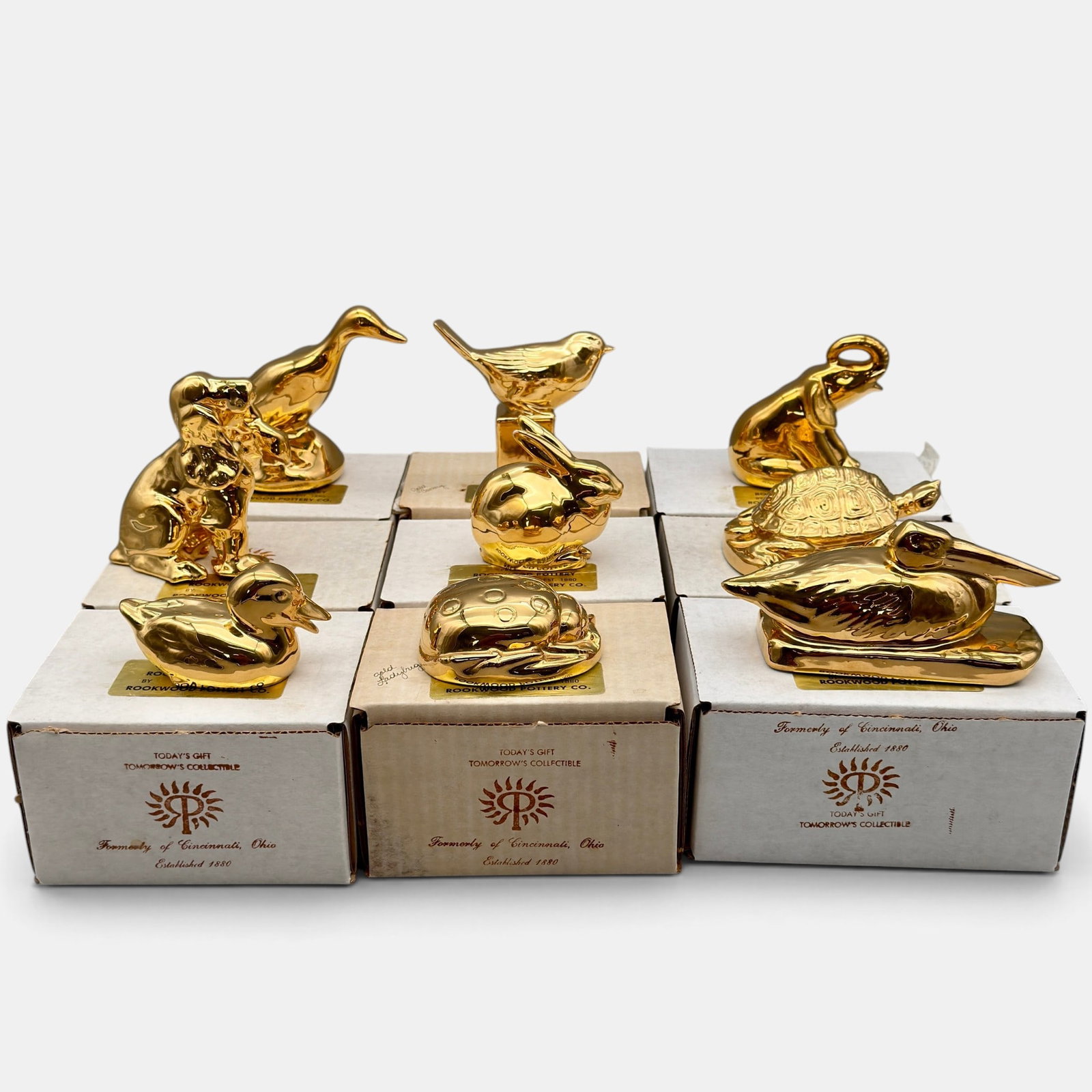 Group of 9 Townley era Rookwood paperweights in gold: Assembled group of nine Townley era Rookwood paperweights in 24 K gold finish including rabbit, pelican, spaniel, canary, goose, duck, sitting elephant, ladybug and turtle. Each is of a limited