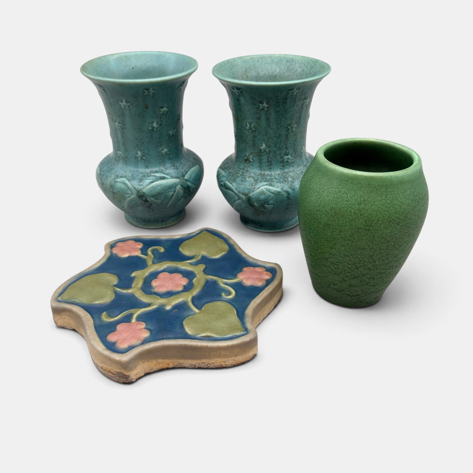 Four Rookwood items, two matching vases, Z-line vase and spiral tile: Four Rookwood items. 1 and 2. Two matching production vases with joquils and stars, crystalline glaze, Shape 6616 form 1937. 3. Z-line vase with leathery green mat glaze, Shape EZ 31 from 1904. 4. Roo