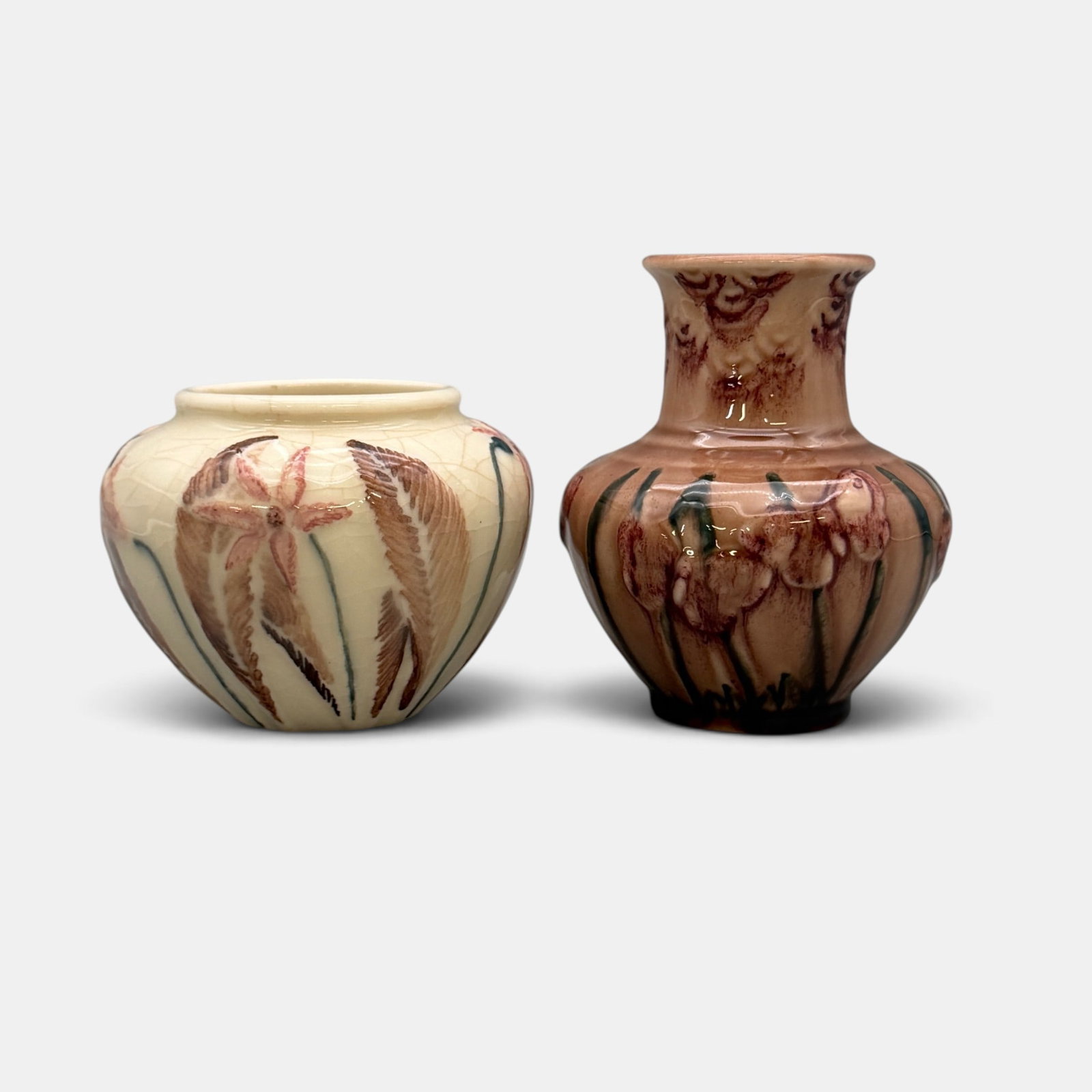 Two Rookwood production vases, hand colored by Junior Decorators in 1945: Two Rookwood production vases with embossed flowers, hand colored by Junior Decorators in 1945. Impressed Roowood logo, XLV, shape numbers 6431 and 6457. Tallest 4 7/8 inches which is signed H.