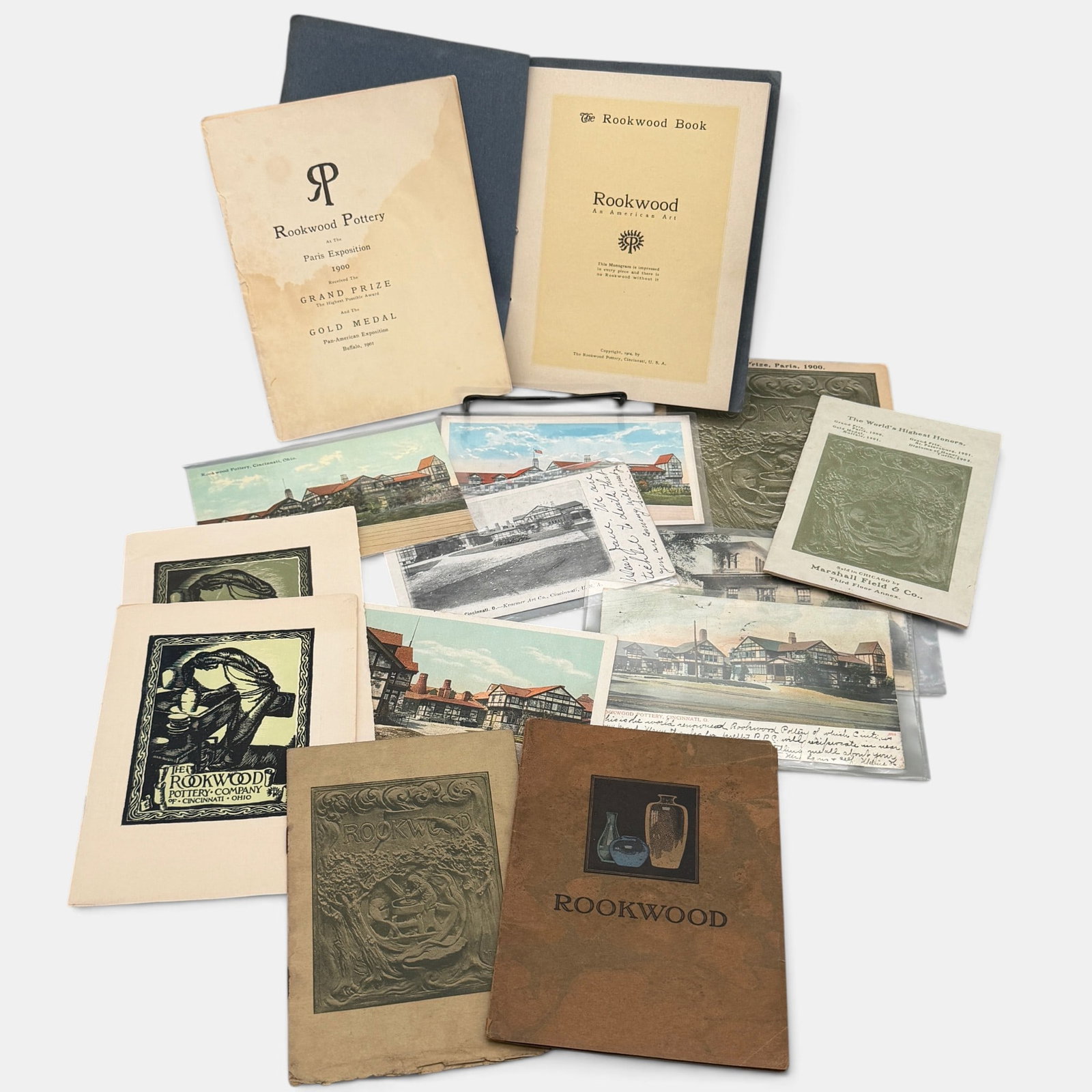 Group of original Rookwood ephemera: Group of original Rookwood printed material including a 1904 Blue Book, mail order catalog, six Rookwood Showroom sales leaflets and 5 Rookwood postcards, one of which is a view of Nicholas Longworth