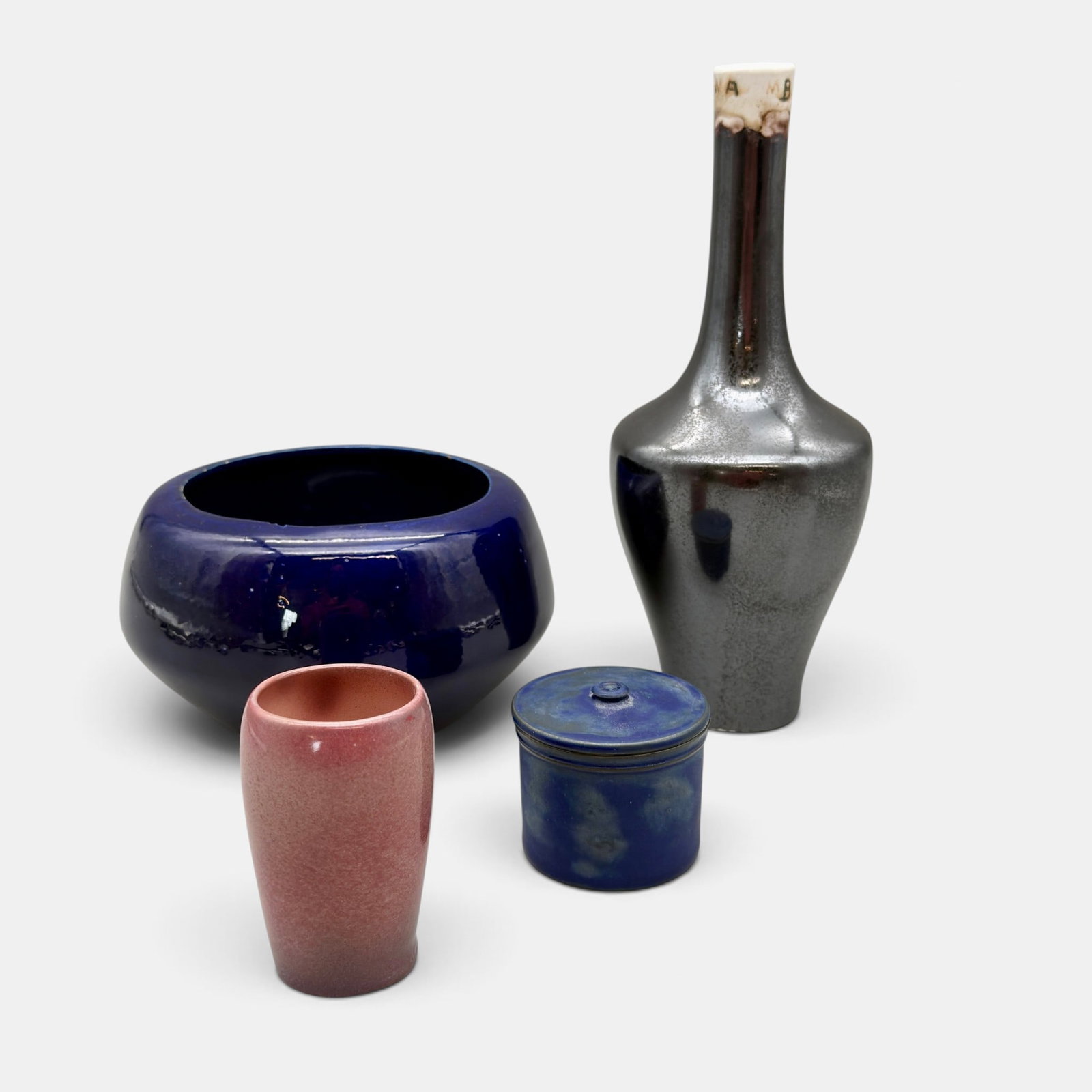 Four University City items, various glazes: Four University City items. 1. Tall crystallin glaze vase, with experimental markings at rim. Impressed UC 1912. 2. Test vase with mottled rose glaze, painted UC, 79. 3. Bowl in cobalt glaze marked