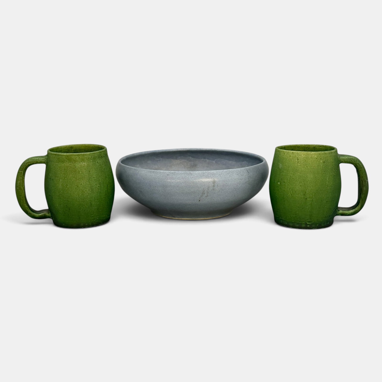 Three Arts & Crafts Pottery Items: Three Arts & Crafts items. 1. Walrath bowl in blue. Incised Walrath. Height 3 inches, diameter 8 5/8 inches. Has an older Rago paper label for lot 0779. 2. A pair of Cambrodge mugs in green mat glaze.