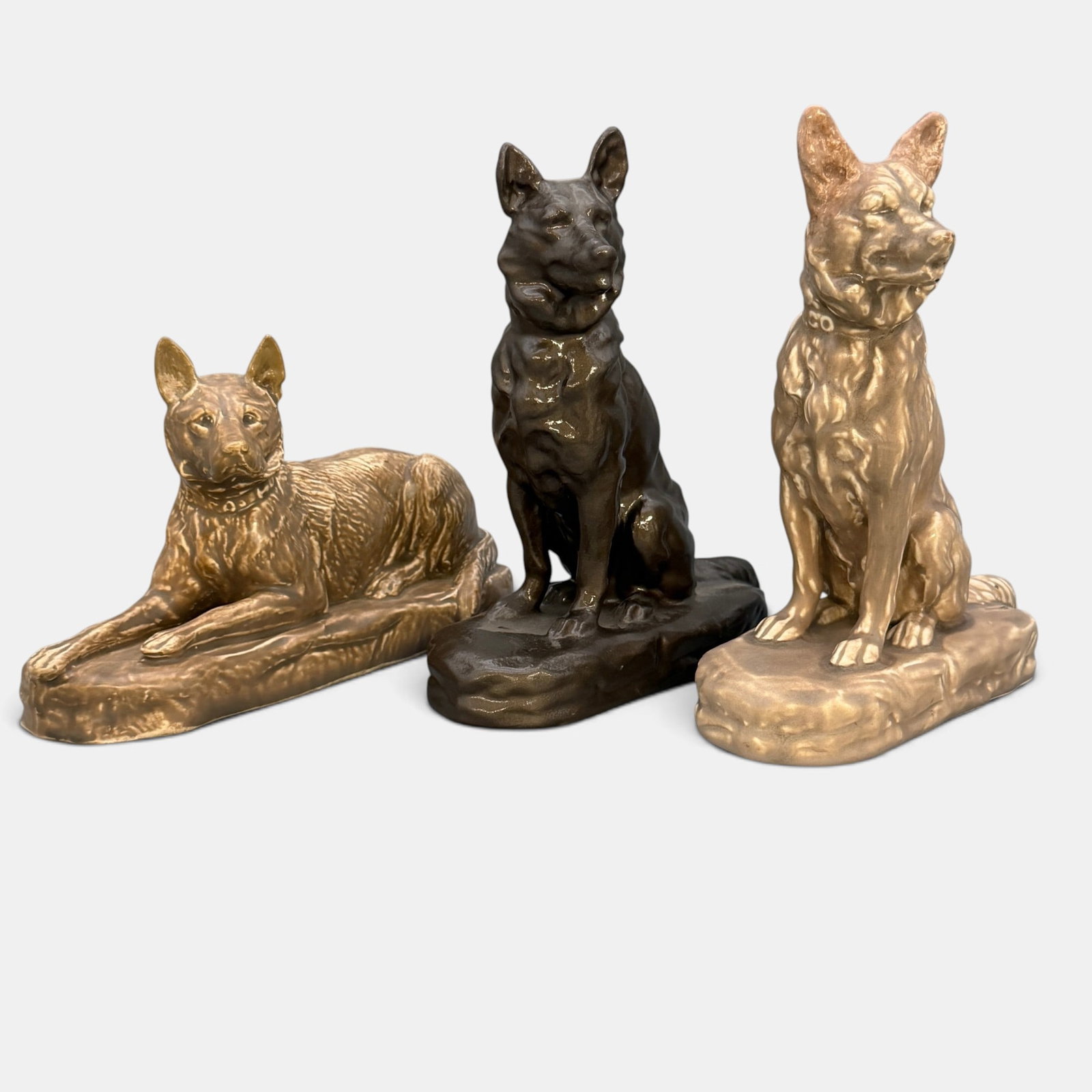 Three German Shepherds, two by Mosaic Tile Co.: Three German Shepherds, two by Mosaic Tile Company and one a copy of Mosaic. The Mosaic dogs are signed on their collars. The other pup is unsigned. Tallest is 9 1/4 inches.
