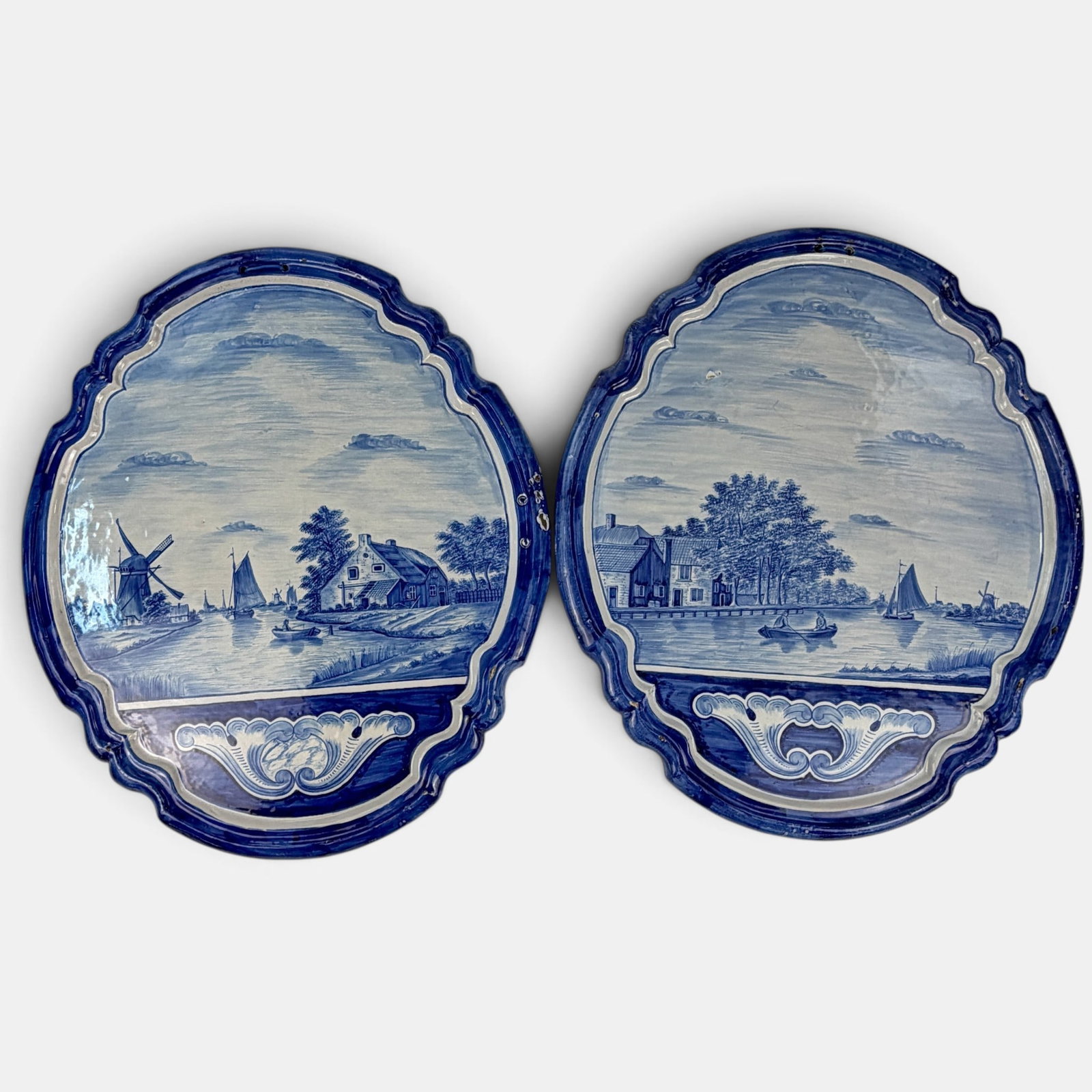 Pair of Dutch Porcelain Plaques: Each Delft style blue and white, each crest shaped plaques, ca. 1900. Each 23" x 20".