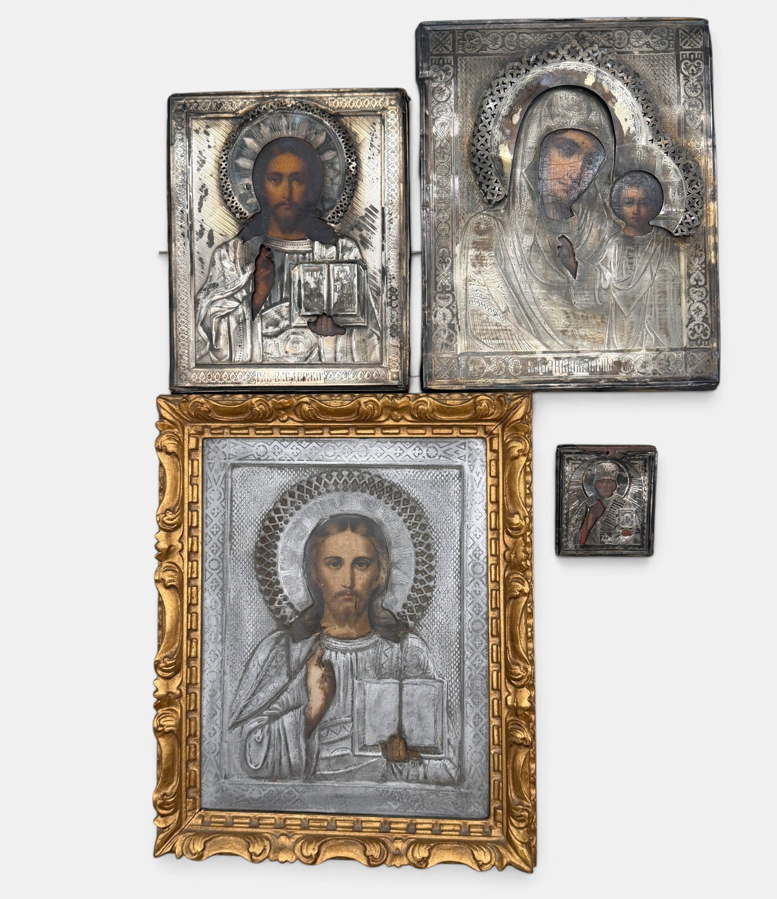 Four Russian Icons: Each 19th century, three with silver overlay (each with assayer marks to fold). Largest 12" x 9.5".