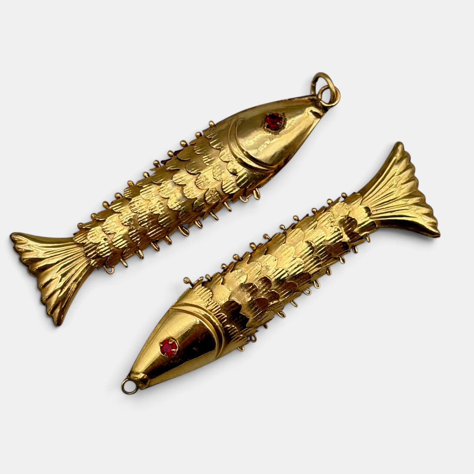 Pair of 10K Reticulating Fish Earrings: Tested for 10k gold, both with inset stone eyes. Total weight: 7 grams