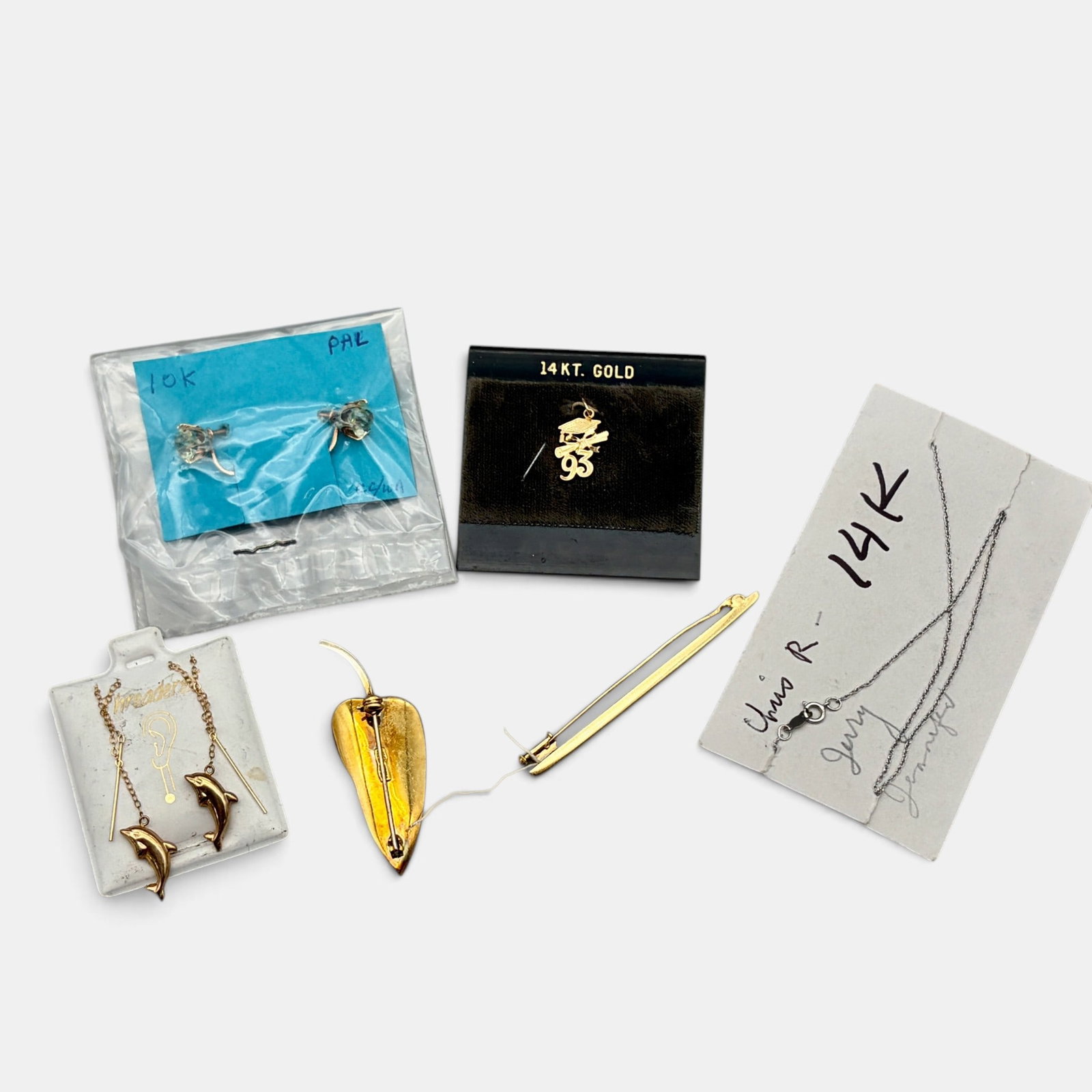 18k and 14k Jewelry: Including an 18k tie bar, and an 18k leaf pendant. These weigh .3 ozt. Additionally, there are a pair of dolphin earrings, a pair of 14k earrings with CZ, a 14k graduation pin, and a white gold 14k