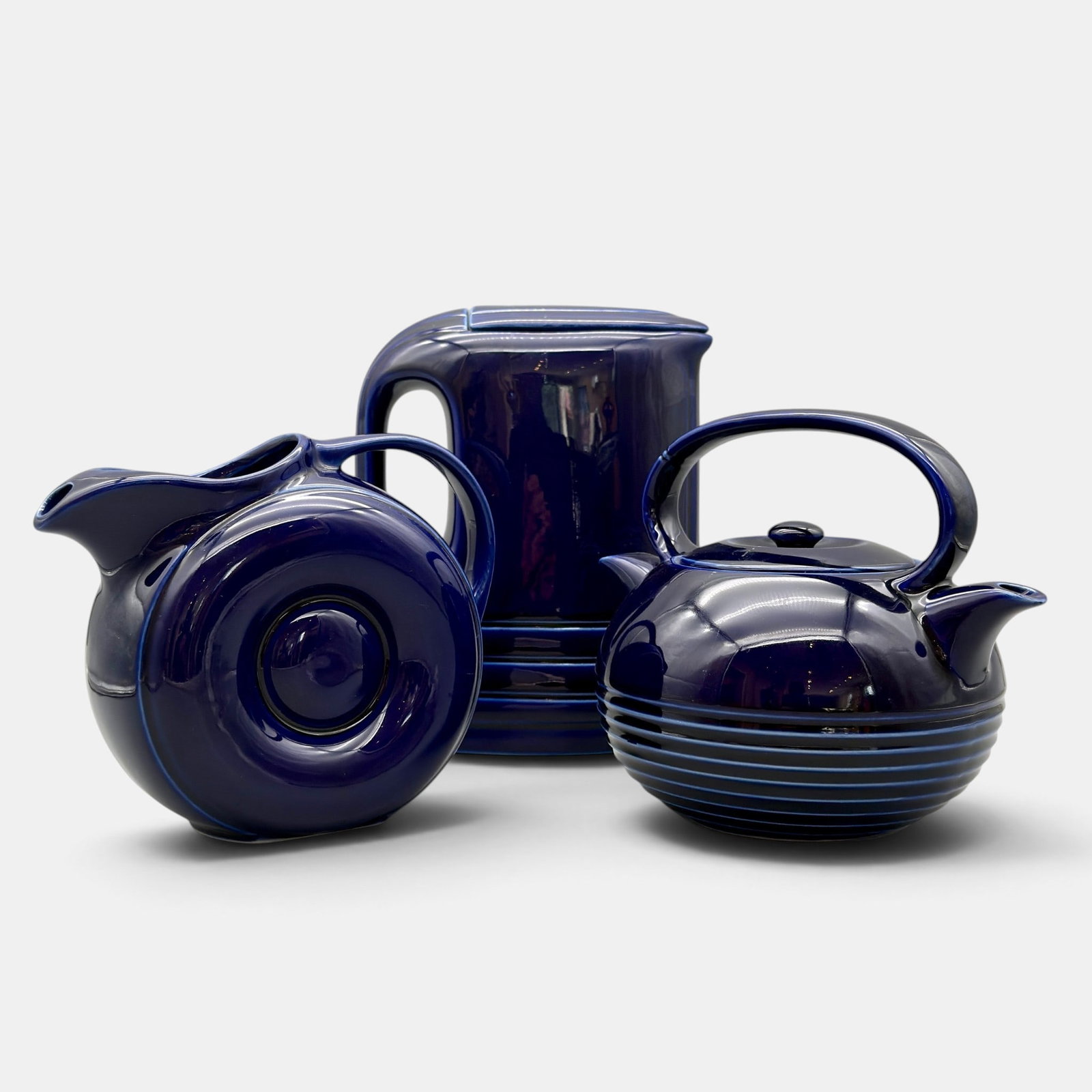 Group of three Hall China items in cobalt.: Group of three Hall China Company items including a Hercules pitcher with lid made for Westinghouse, a rare Twin Spout teapot with llid designed by Oscar Ottoson and a Donut pitcher, all in cobalt
