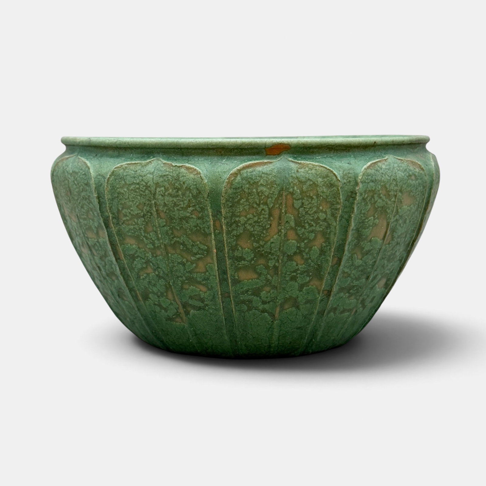 Grueby low vase with 11 leaves, Ruth Erickson.: Grueby Pottery low vase with 11 leaves, hand tooled by Ruth Erickson. Impressed Grueby Pottery logo, incised R.E. 8/3. Cincinnati Art Galleries paper label for lot 0186. Height 5 5/8 inches, diameter 