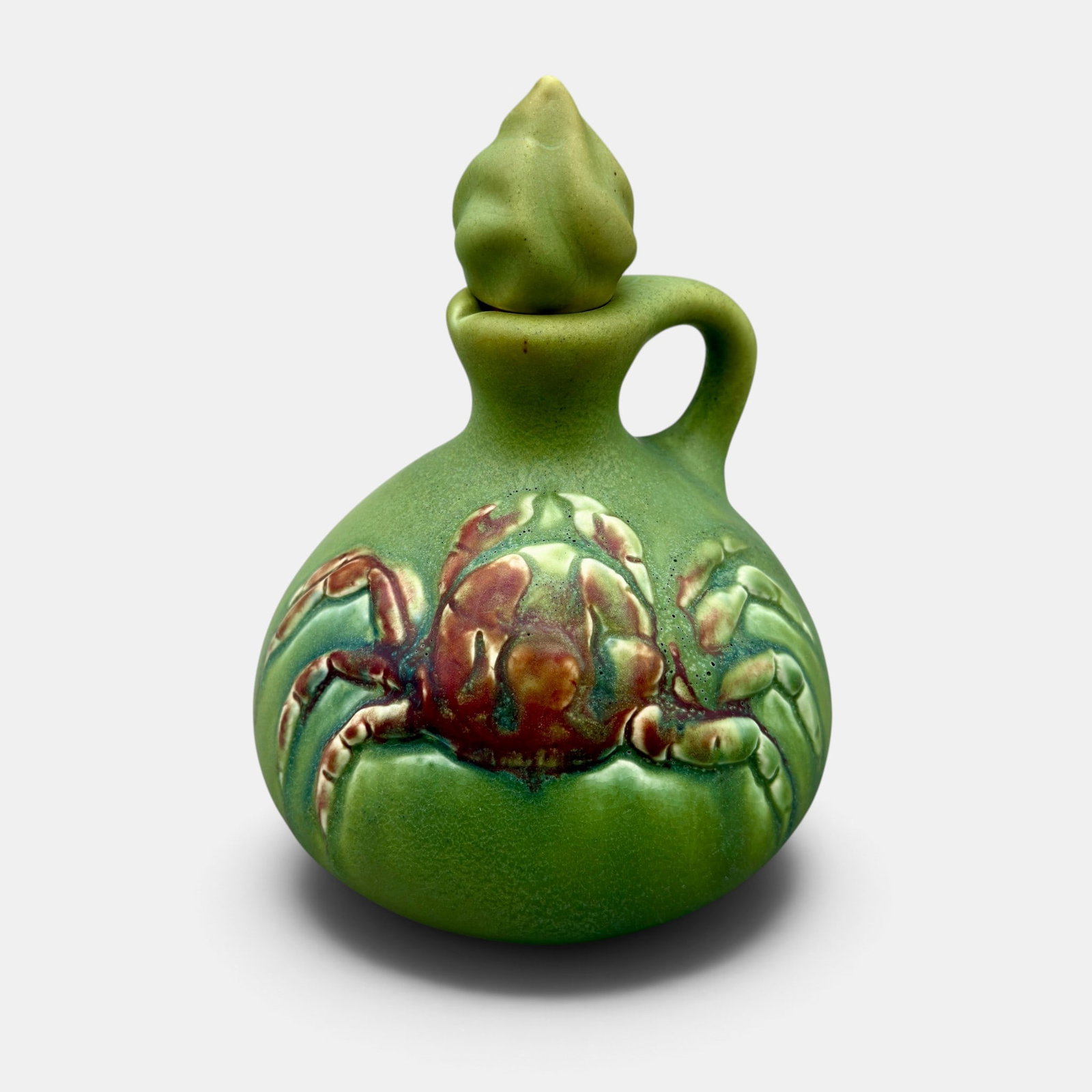 Rookwood carved mat glaze whiskey jug, Fechheimer, 1905.: Carved Rookwood mat glaze whiskey jug with crab decoration and appropriate stopper, done by Rose Fechheimer in 1905. Impressed Rookwood logo, V, Shape number 889 C. Incised Fechheimer monogram.