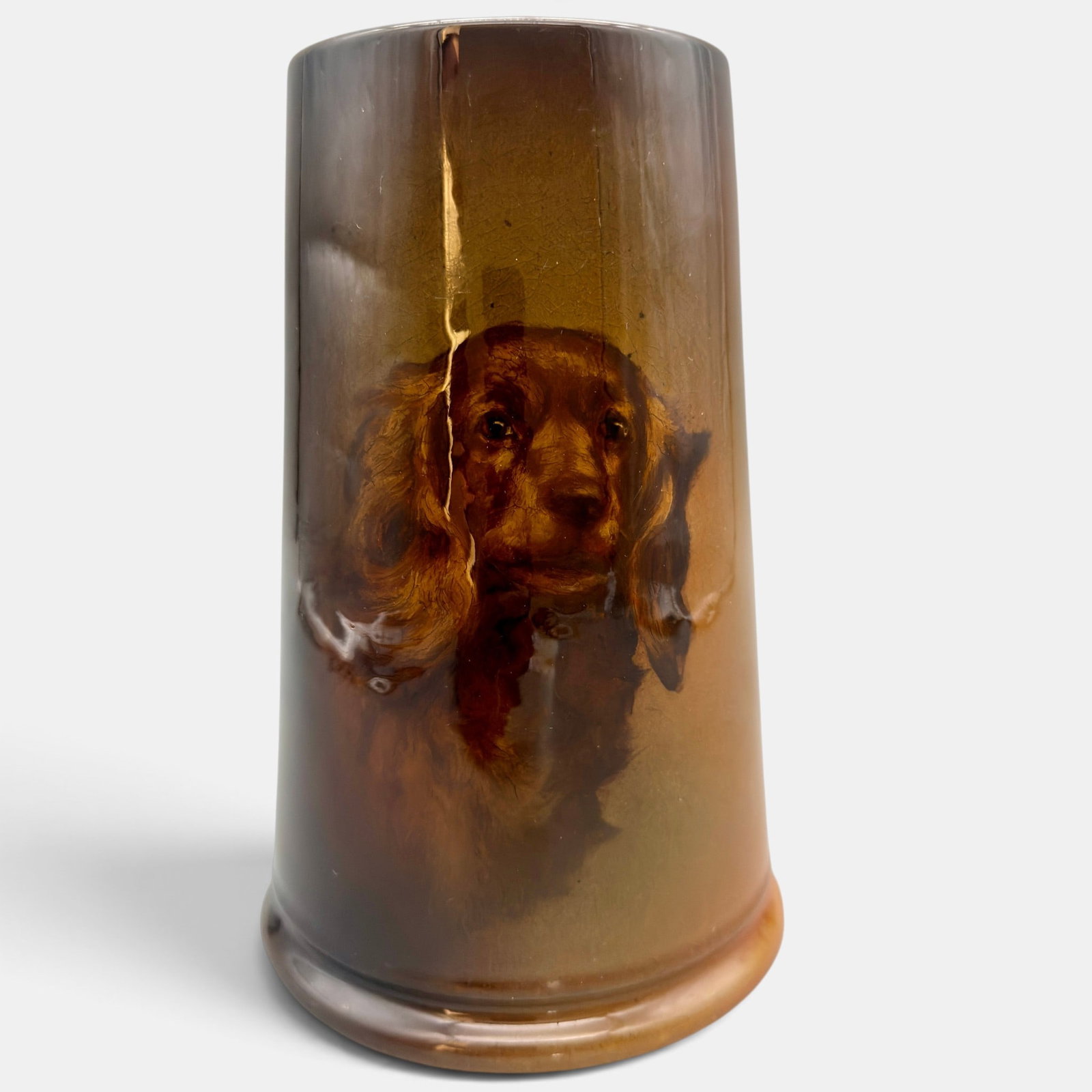 Tall Standard glaze mug, Spaniel. Hurley, 1901: Tall Rookwood Standard glaze mug with a life-like image of a Spaniel dog done by E.T. Hurley in 1901. Impressed Rookwood logo, I, Shape number 775, incised ETH. Glover Collection paper label for lot 3
