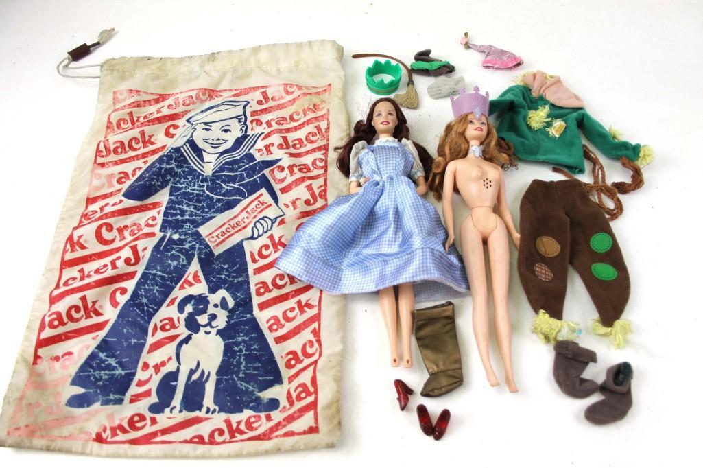 Wizard of Oz Barbies and Accessories plus a Cracker: Wizard of Oz Barbies including Dorothy and Glinda the Good Witch plus some Clothes and Accessories and a Cracker Jack Draw String Bag Condition: Draw string bag has some wear and grime