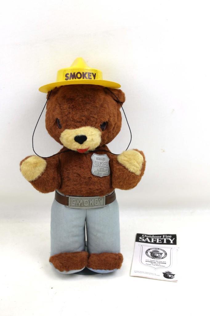 Vintage Plush Smokey The Bear With Pamphlet: Vintage Smokey The Bear Stuffed Animal With Pamphlet . He is the mascot for the US Forest Service. He has a yellow hat that says " Smokey " , a belt , and his Ranger badge that says " Prev