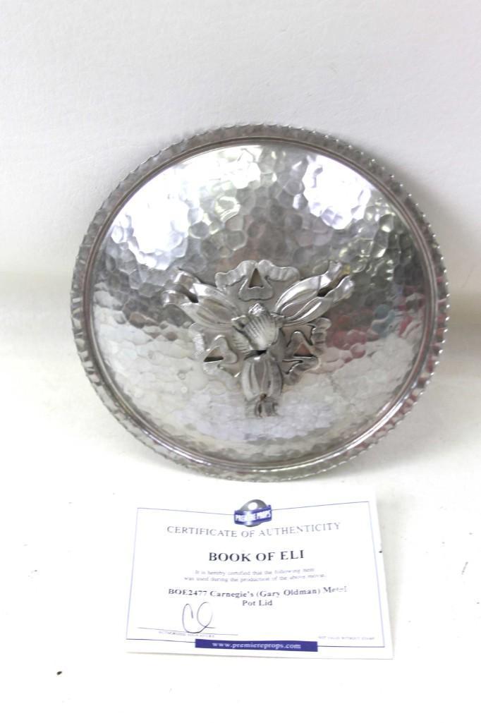 Prop from the Movie Book of Eli Carnegie's Metal pot: Authentic movie prop from Book of Eli . BOE2477 Carnegie's ( Gary Oldman ) metal pot lid with the certificate of authenticity