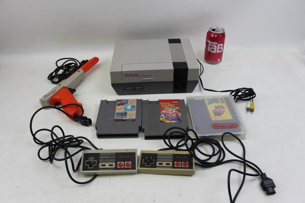 Original NES Nintendo Lot: Original NES Nintendo Lot Includes the NES console, the light gun, two controllers, AV cords, Super Mario Bros. 3, Double Dragon and the Super Mario/ Duck Hunt / World Class Track Meet Does not have t