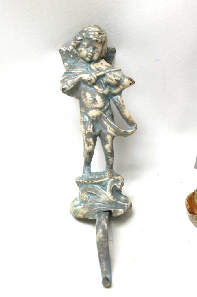 Cast Iron Cherub hook of sorts: Cast Iron Cherub hook of sorts It can sit on an edge and has a hook, but if something is too heavy, it will fall over.