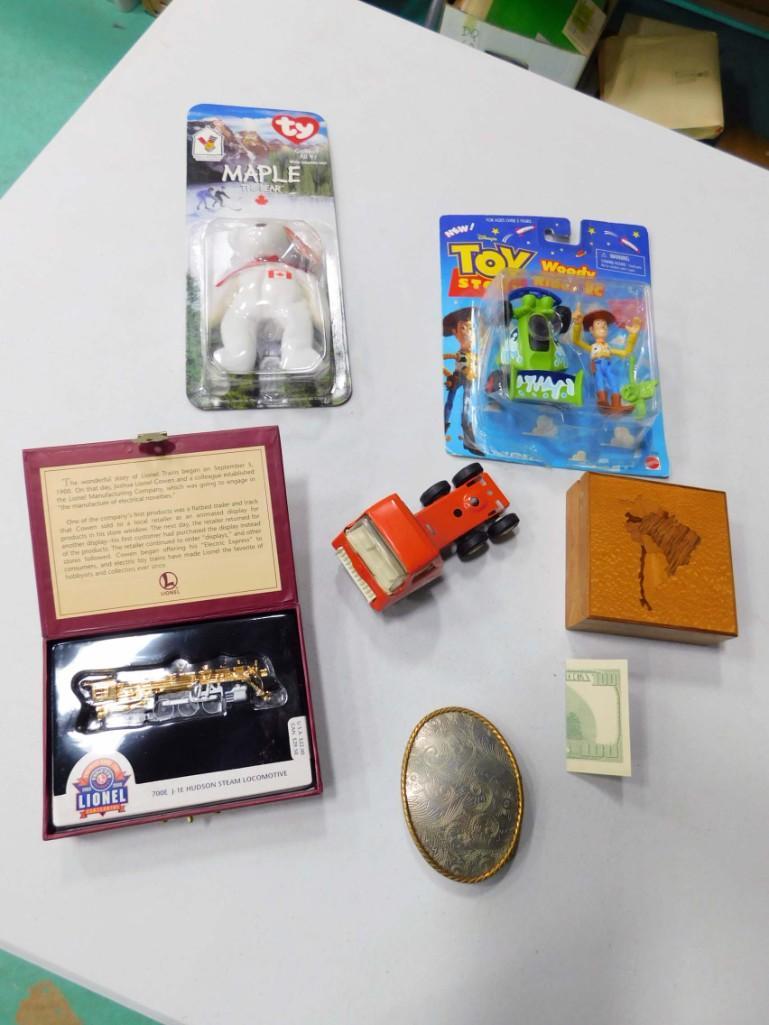 Tonka Trailer , Lionel Hallmark Ornament , Belt Buckle: Tonka Trailer , Lionel Hallmark Ornament , Belt Buckle , Toy Story Woody Figure NIP , Ty Canadian Bear , Wood Inlay Trinket Box , and a 100 dollar bill magic trick