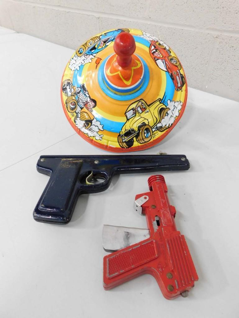 Vintage Toy Lot incl Tin Litho Top and 2 Metal Toy Guns: Vintage Toy Lot incl Tin Litho Spinning Top and 2 Metal Toy Guns Condition: played with condition. Toy has some dents, dings, scratches, etc. To guns have some wear