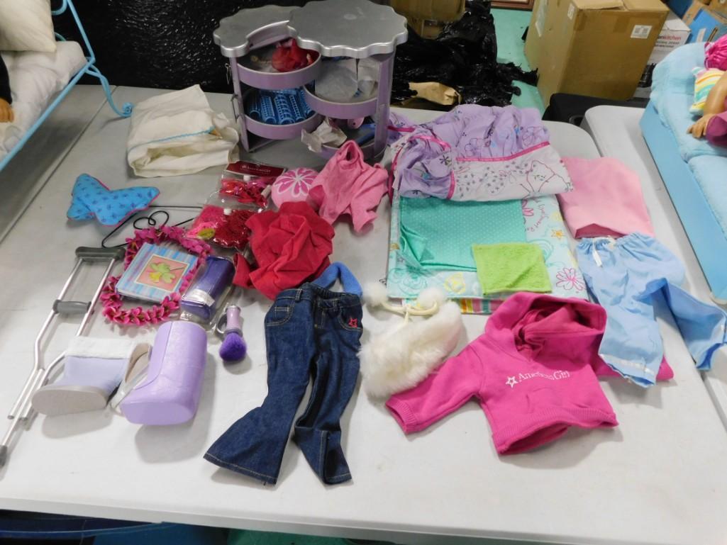American Girl Doll Clothing and Accessories: American Girl Doll Clothing and Accessories including a crutch, jeans, hair rollers, a single boot, a purple cast/boot, hanger, linens, etc. What sheet with blue stripe in the top corner of the first 