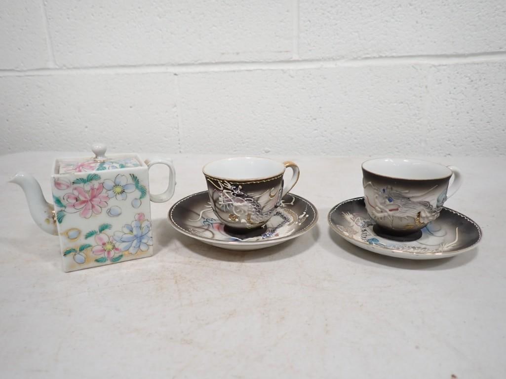 Pair of Lithopane Teacups with saucers and a small porcelain tea pitcher: Pair of Lithopane Teacups with saucers and a small porcelain tea pitcher. Tea cups have an image of two nude Asian women on one and an Asian Lady face on the other
