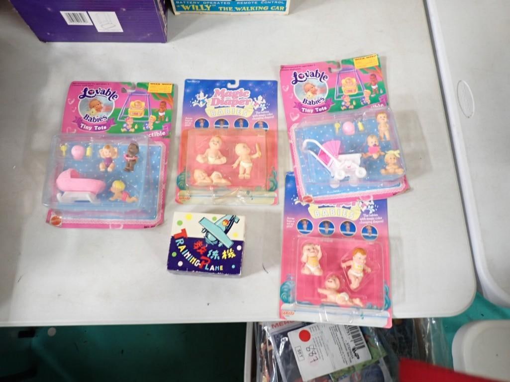 4 Loveable Babies Dolls and 1 Training Plane Toy: 4 Loveable Babies Dolls and 1 Training Plane Toy Dolls in Original Packages, packages show shelf wear . Tiny Plane Toy is a wind-up Japanese toy in original box with original instructions. Box has bee