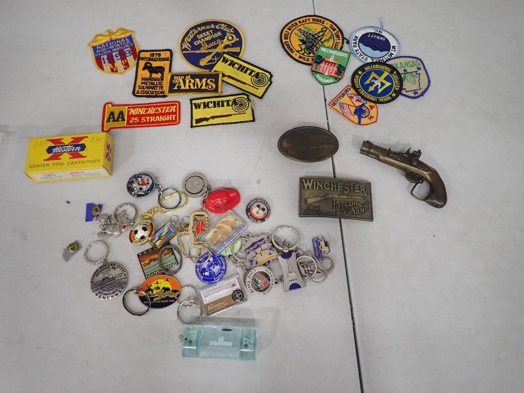 Belt Buckles, Embroidered Patches, Key Chains, etc incl Pistol Belt Buckle, Winchester Embroidered: Lot of Smalls including Belt Buckles, Embroidered Patches, Key Chains, Pins, etc incl Pistol Belt Buckle, Winchester Embroidered Patch, Winchester Belt Buckles, etc. Includes an EMPTY Western X 