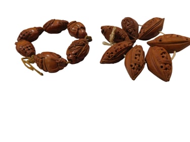 Two Strands of Chinese Carved Nut Beads Including six carved figural nut beads and seven boat form