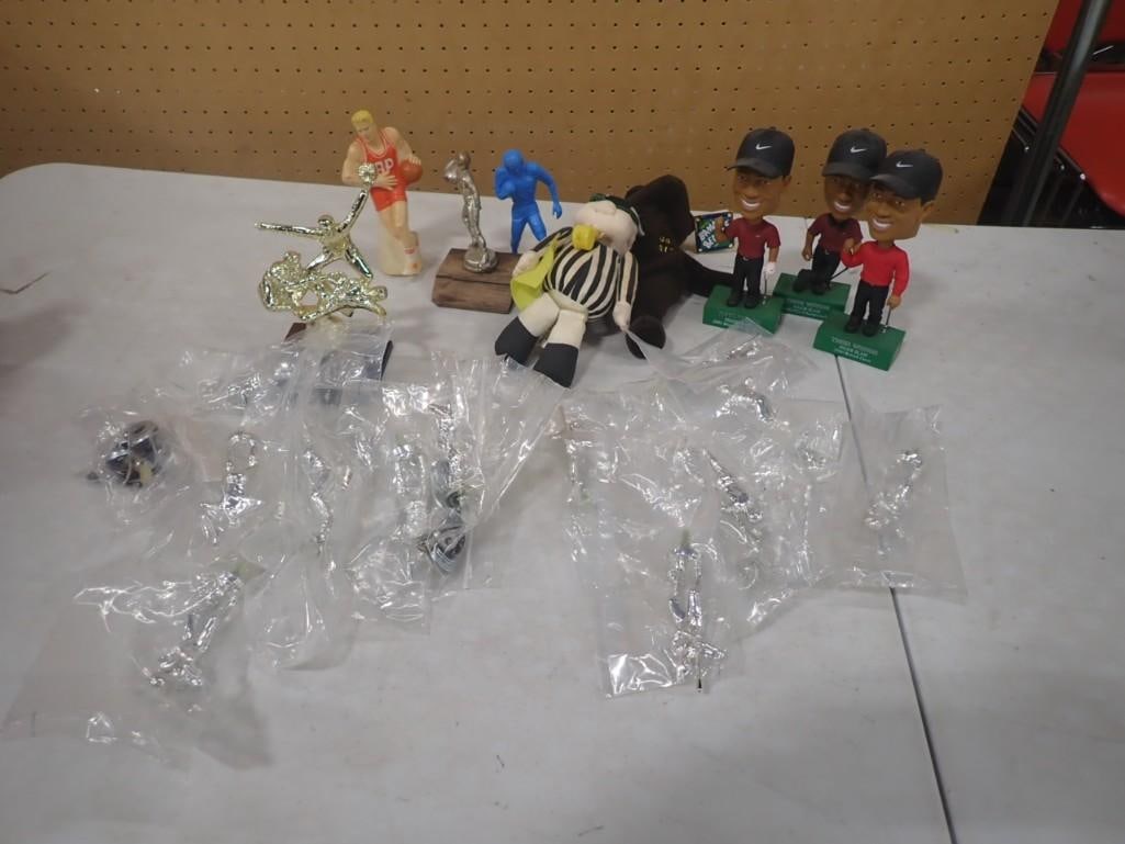 Sports Collectibles Lot including Tiger Woods Bobble Heads, Plush Referee, Figures, Trophy Tops, etc: Sports Collectibles Lot including Tiger Woods Bobble Heads, Plush Referee, Figures, Trophy Tops, etc. All pictures are considered part of the description and should be examined carefully by bidders. L