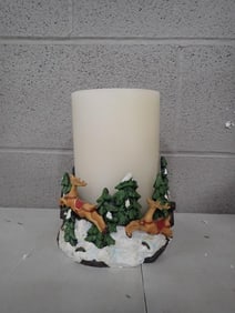 Flameless LED candle with a decorative base featuring a Christmas-themed scene with reindeer and pin