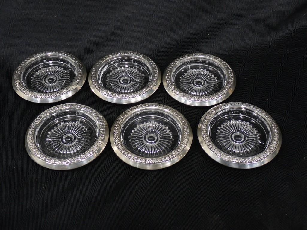 A set of 6 Watrous sterling silver and glass coasters. Sterling silver rim bears rose blossom and l: A set of 6 Watrous sterling silver and glass coasters. Sterling silver rim bears rose blossom and leaves pattern, with starburst glass. Diameter: 4" All pictures are considered part of the description